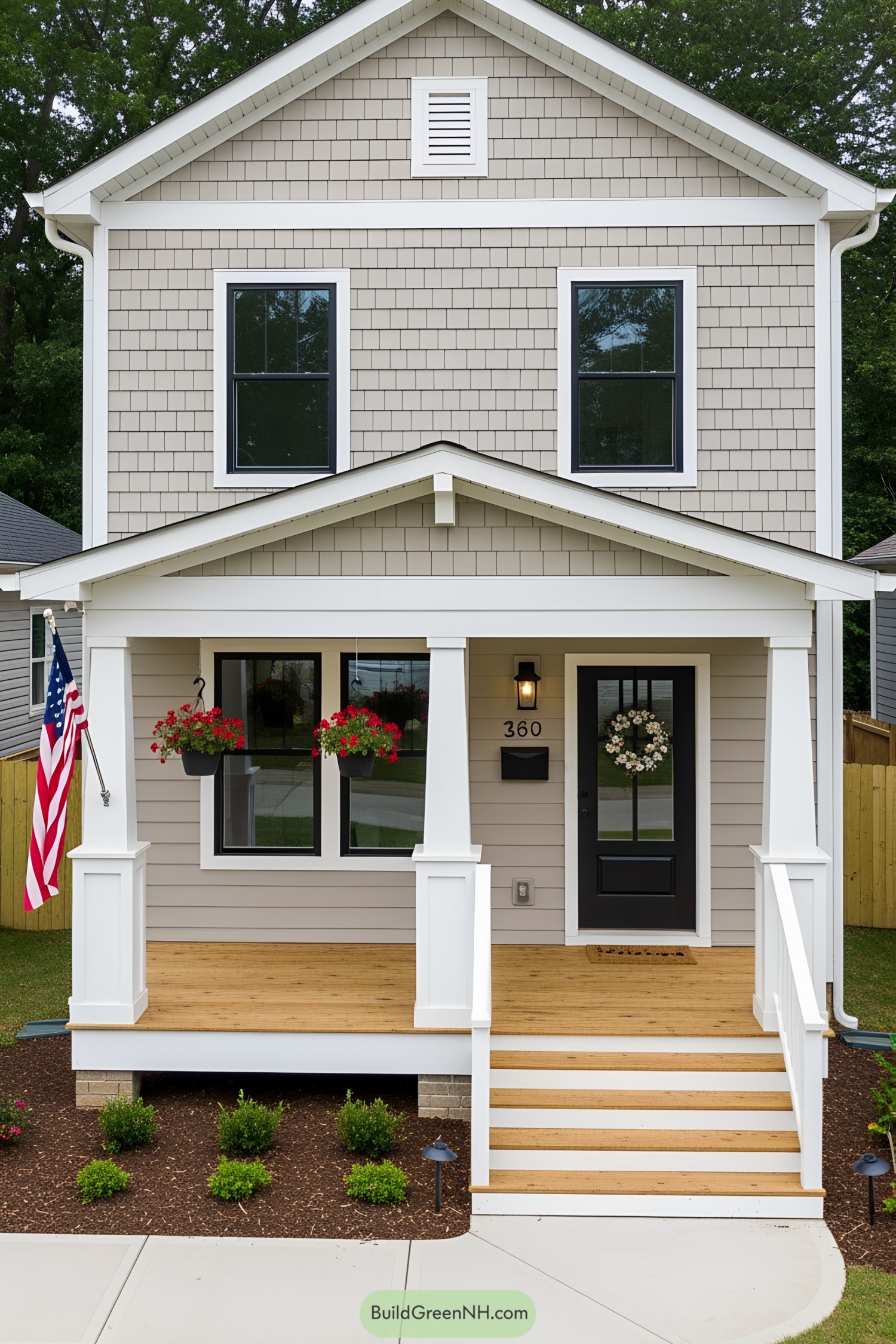 Beige house with white columns, a black door, and hanging flowers