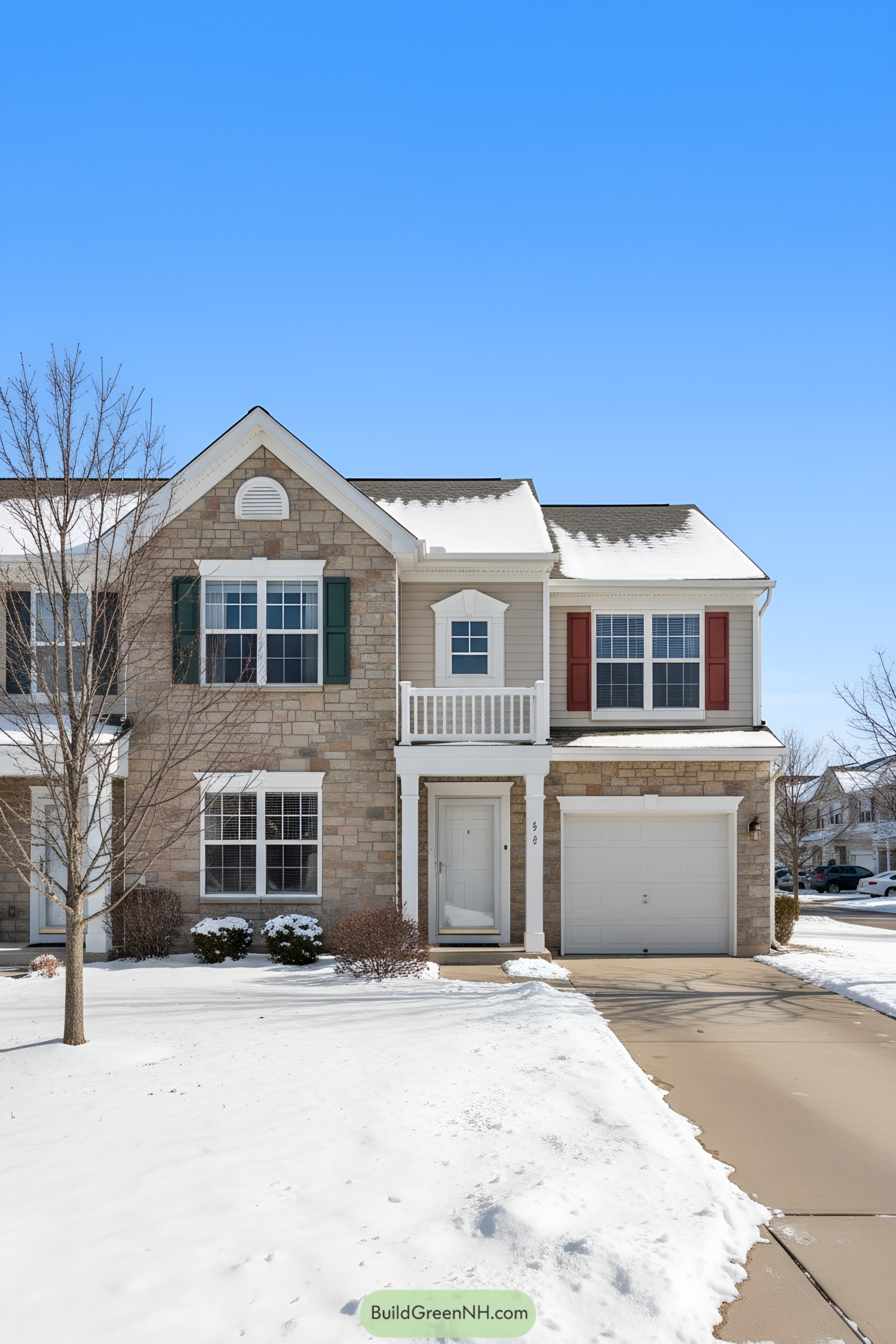Suburban townhouse with stone and siding facade in snow