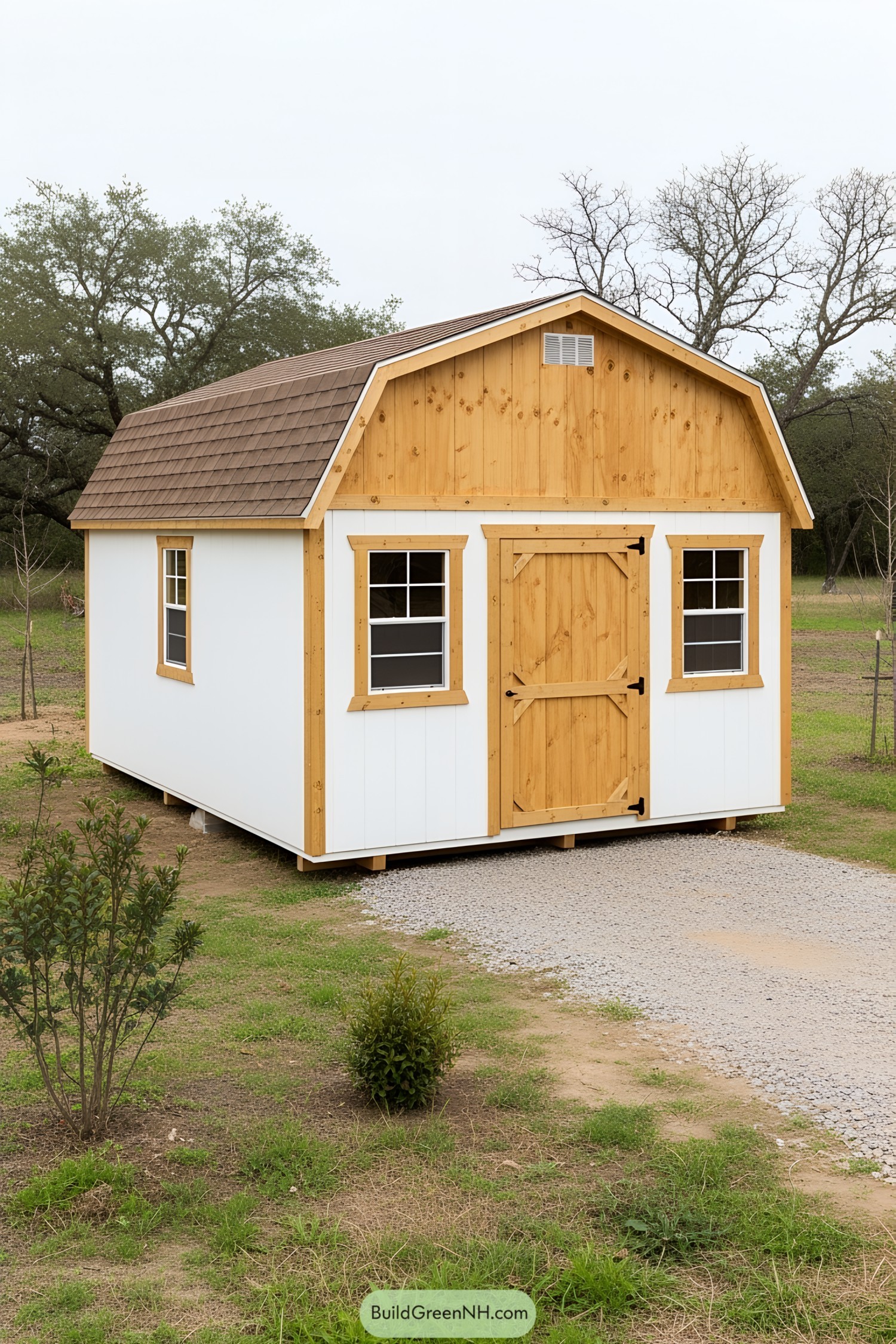 A wooden shed with a peaked roof and gravel path