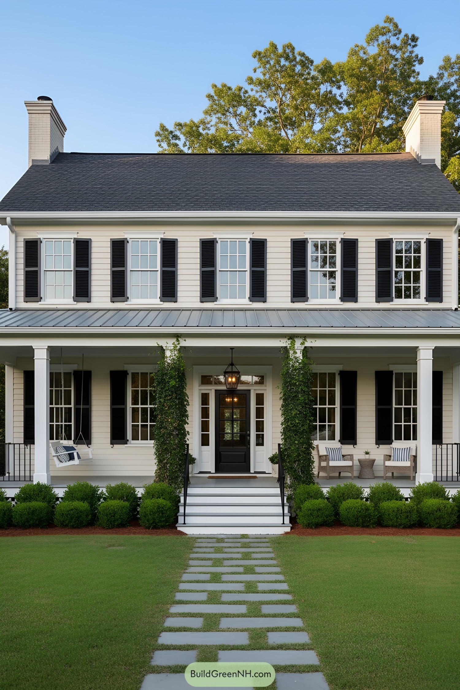 Symmetrical colonial home with black shutters, ivy, and porch swing