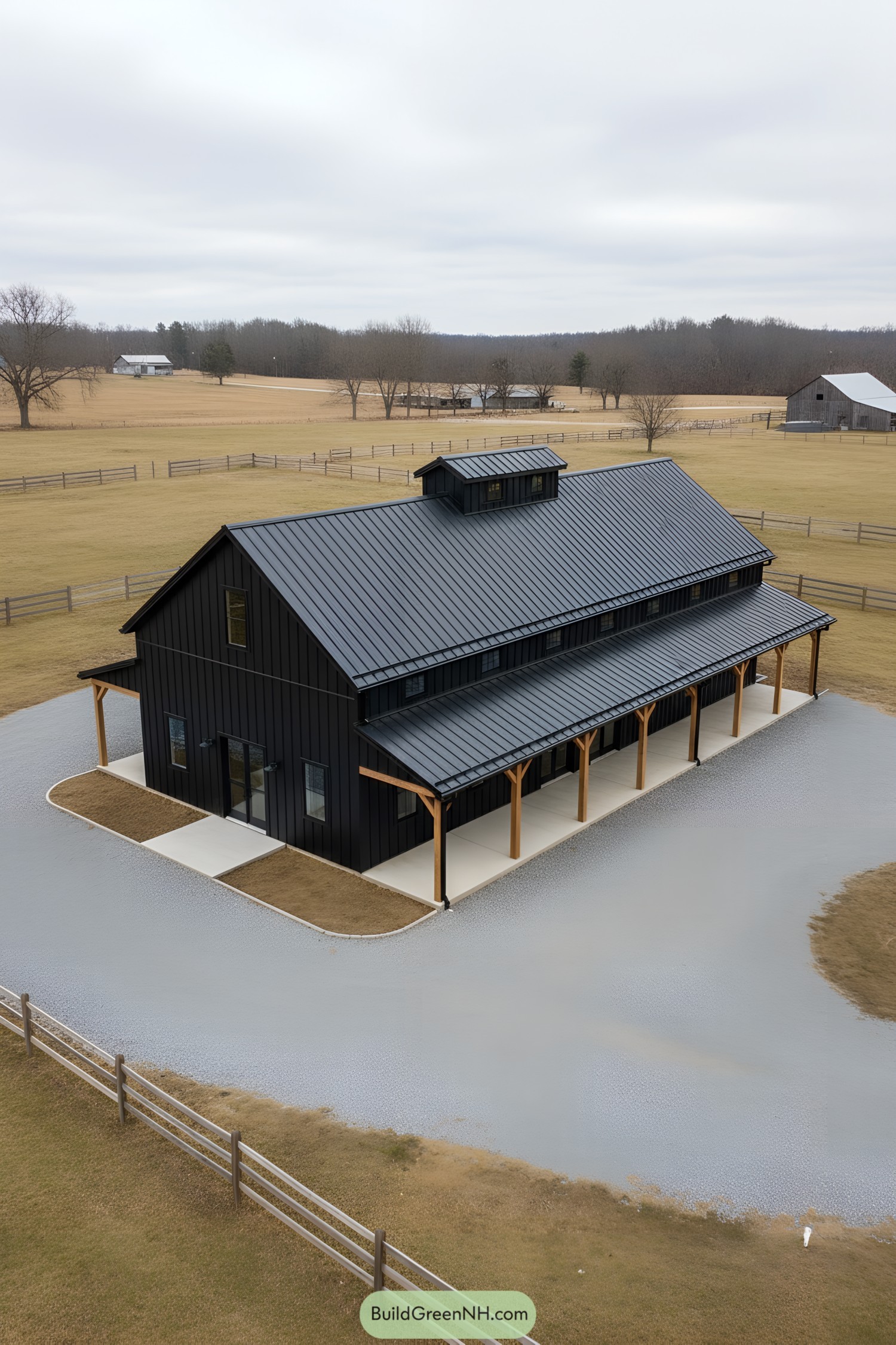 Black metal barn house with long shed porch, timber posts, and cupola