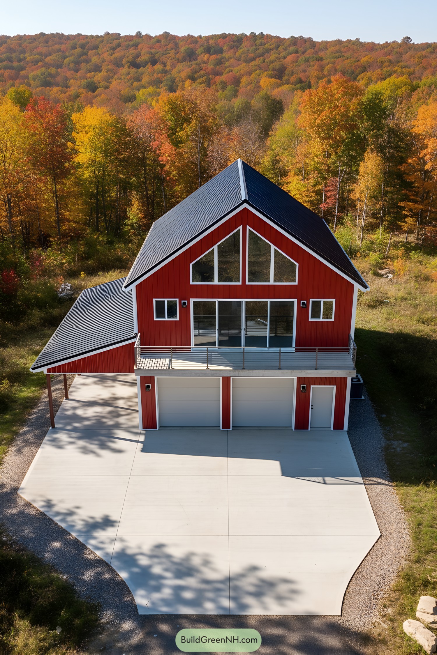 Red metal barn home with A-frame roof, large balcony, and three-bay garage