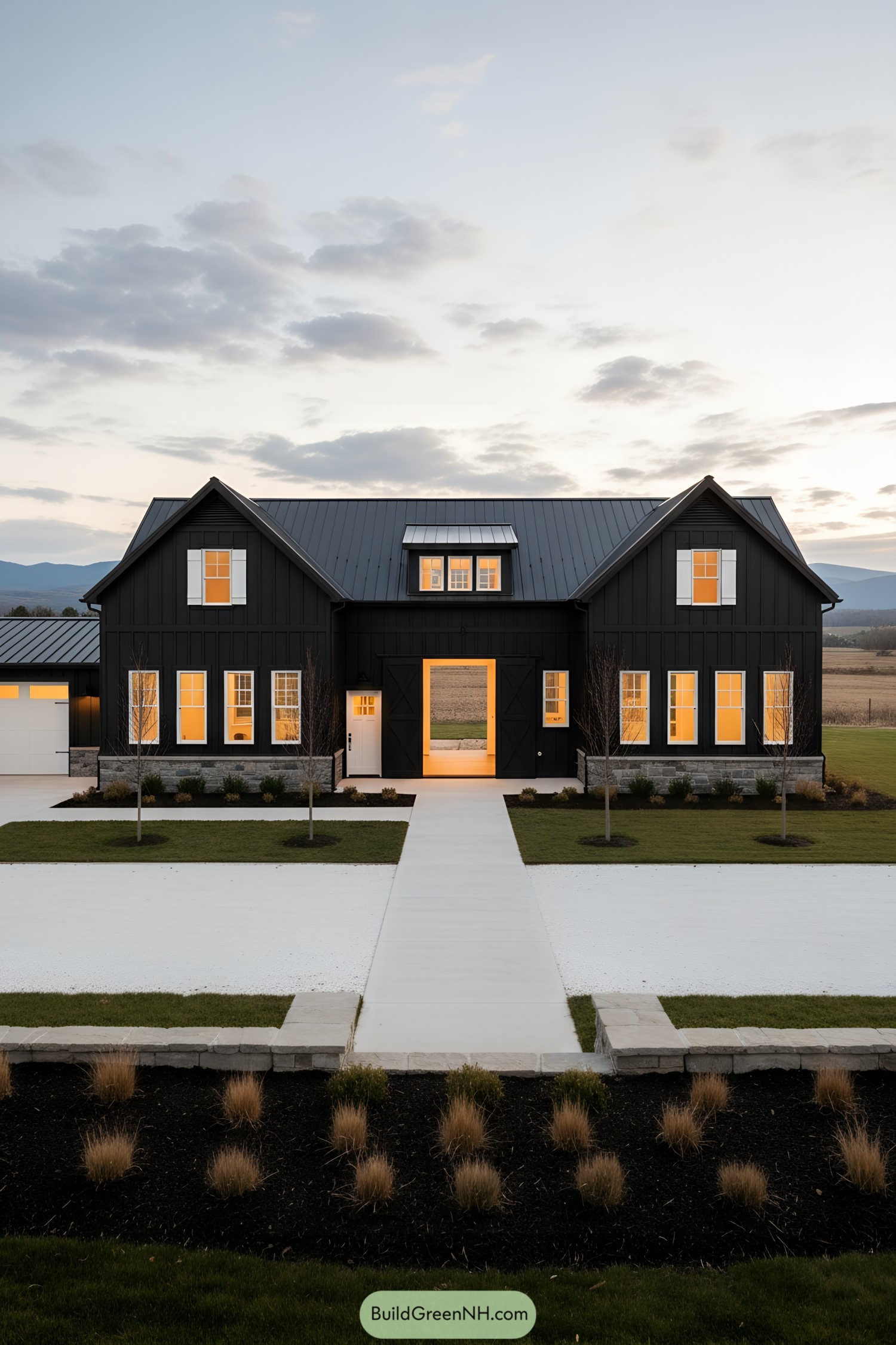 Black barn-style home with warm-lit windows at dusk