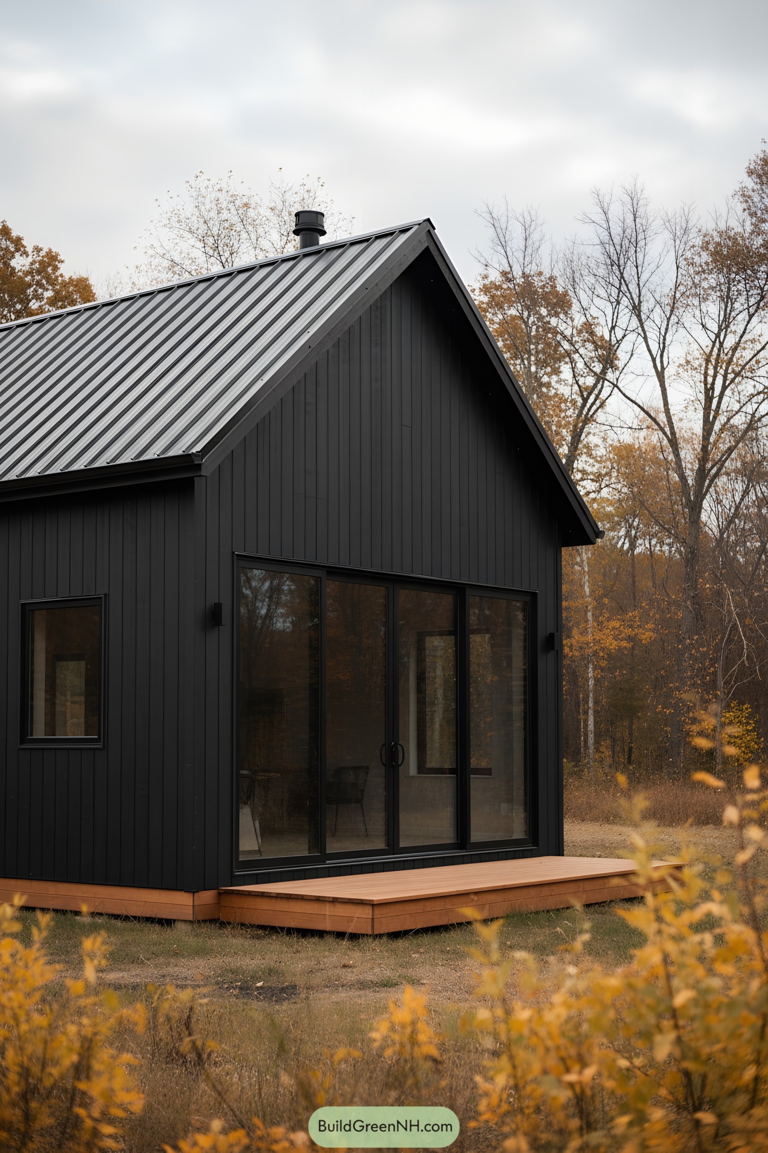 Black barn cabin with metal roof and large sliding glass doors