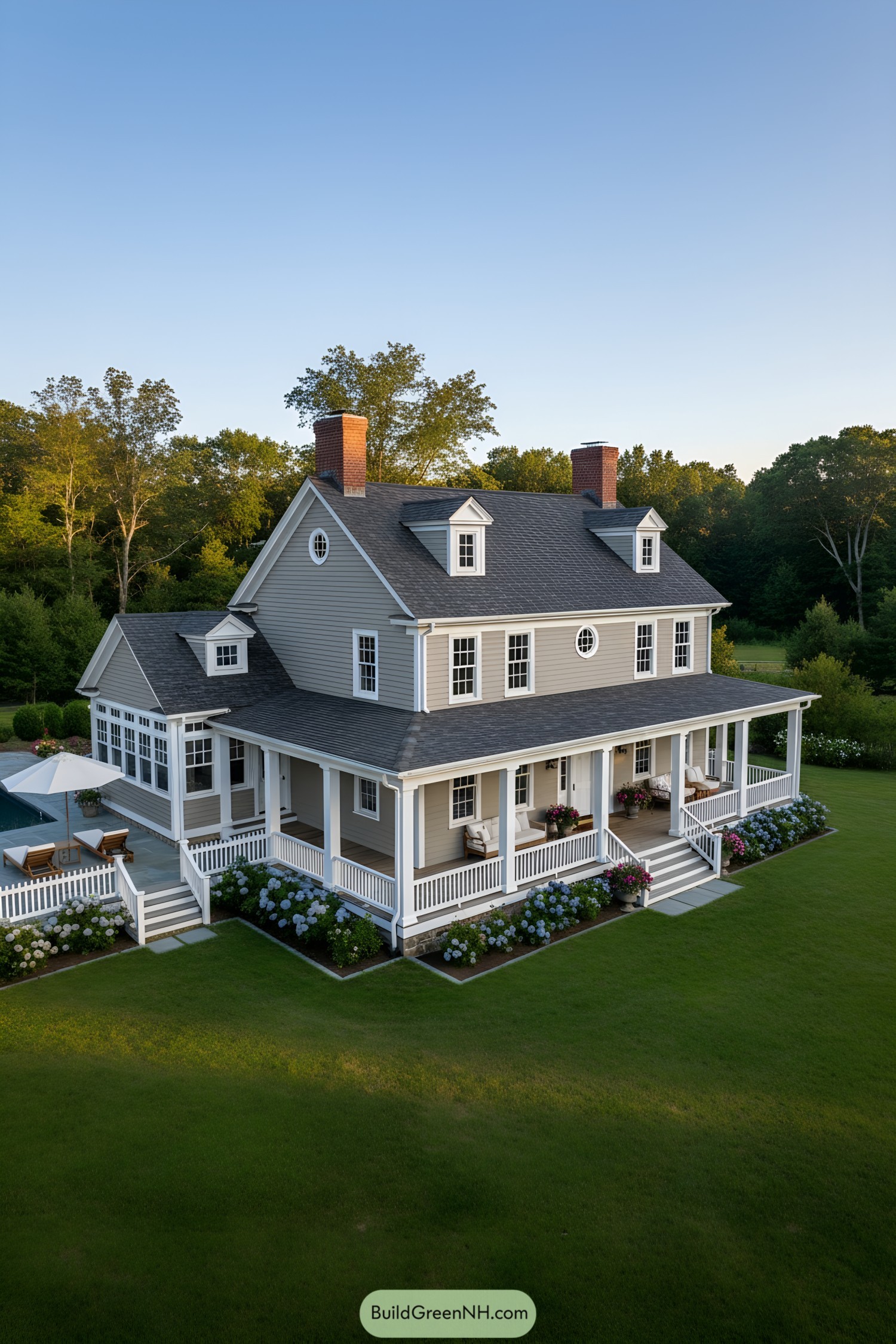 Classic gray clapboard farmhouse with wraparound porch and dormers