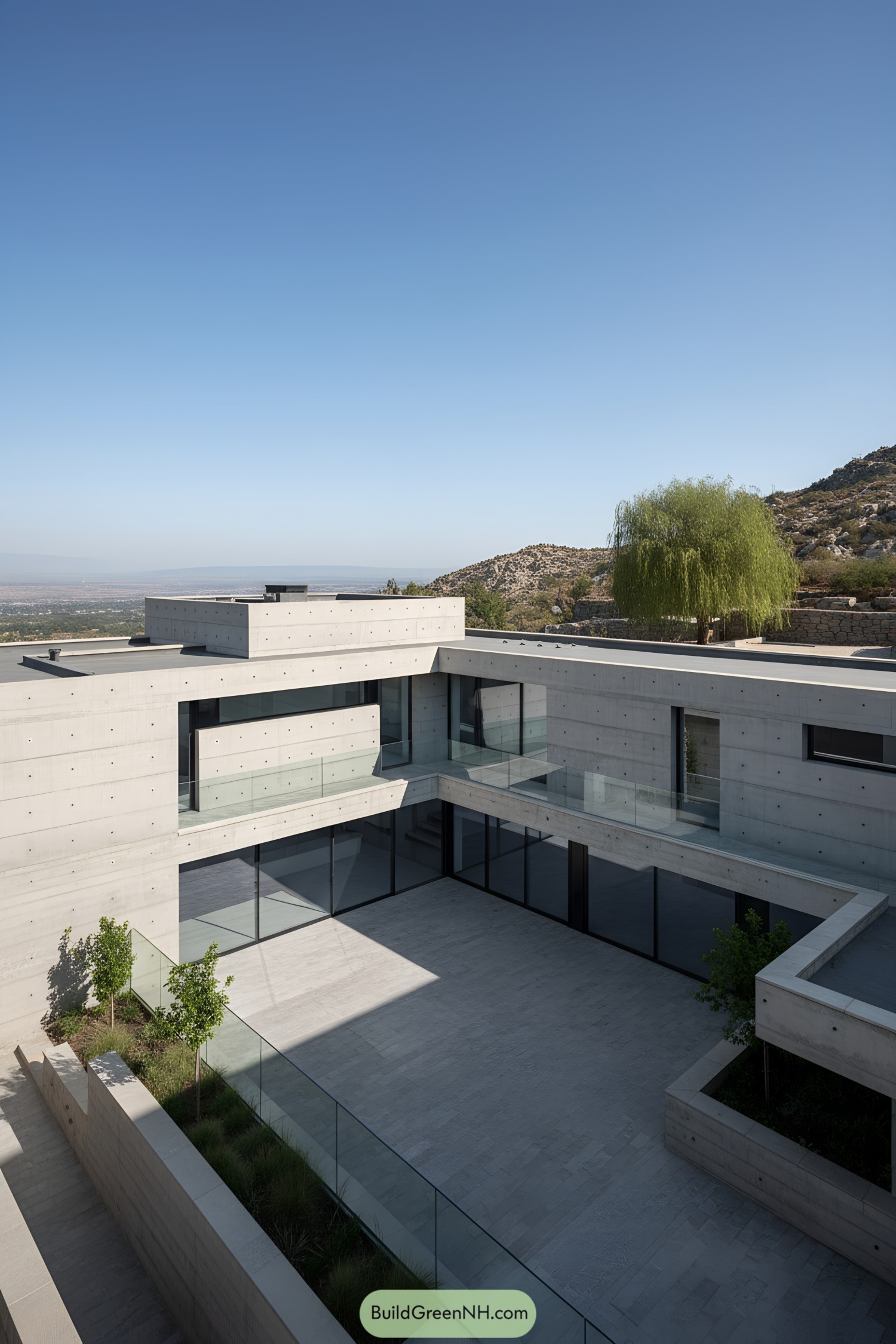 Minimalist concrete villa with U-shaped courtyard and glass balustrades on a hillside