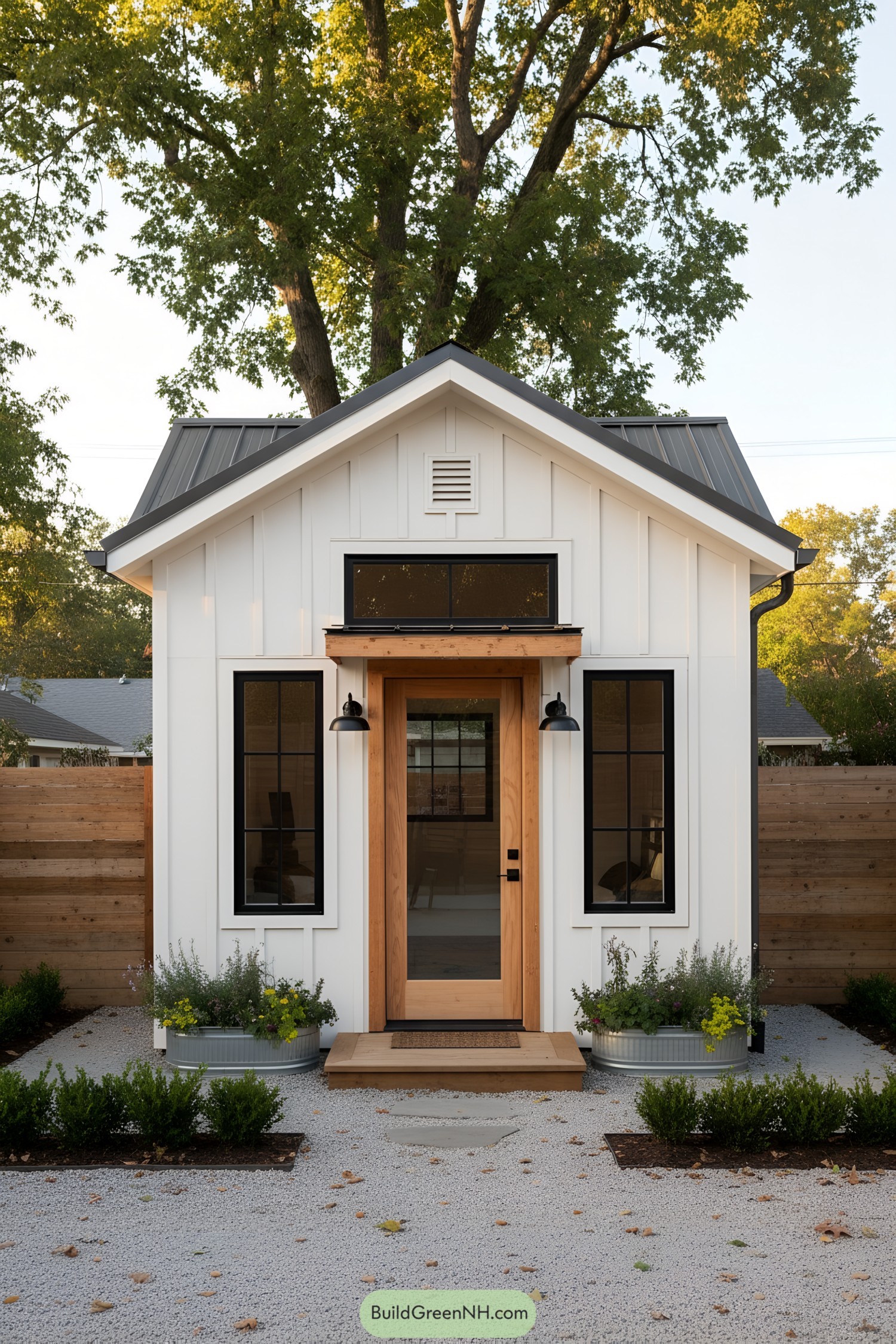 White board-and-batten shed with gabled roof and wood-trimmed glass door