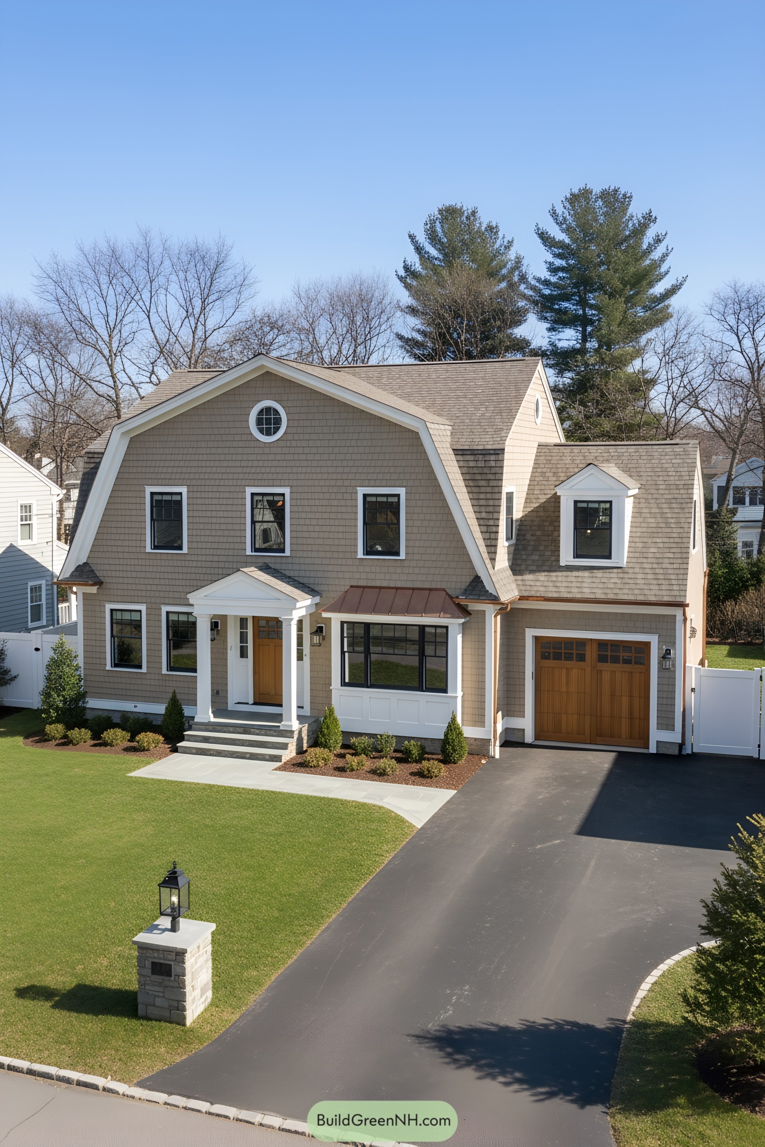 Two-story taupe-shingle gambrel with copper awning, white trim, and wood accents