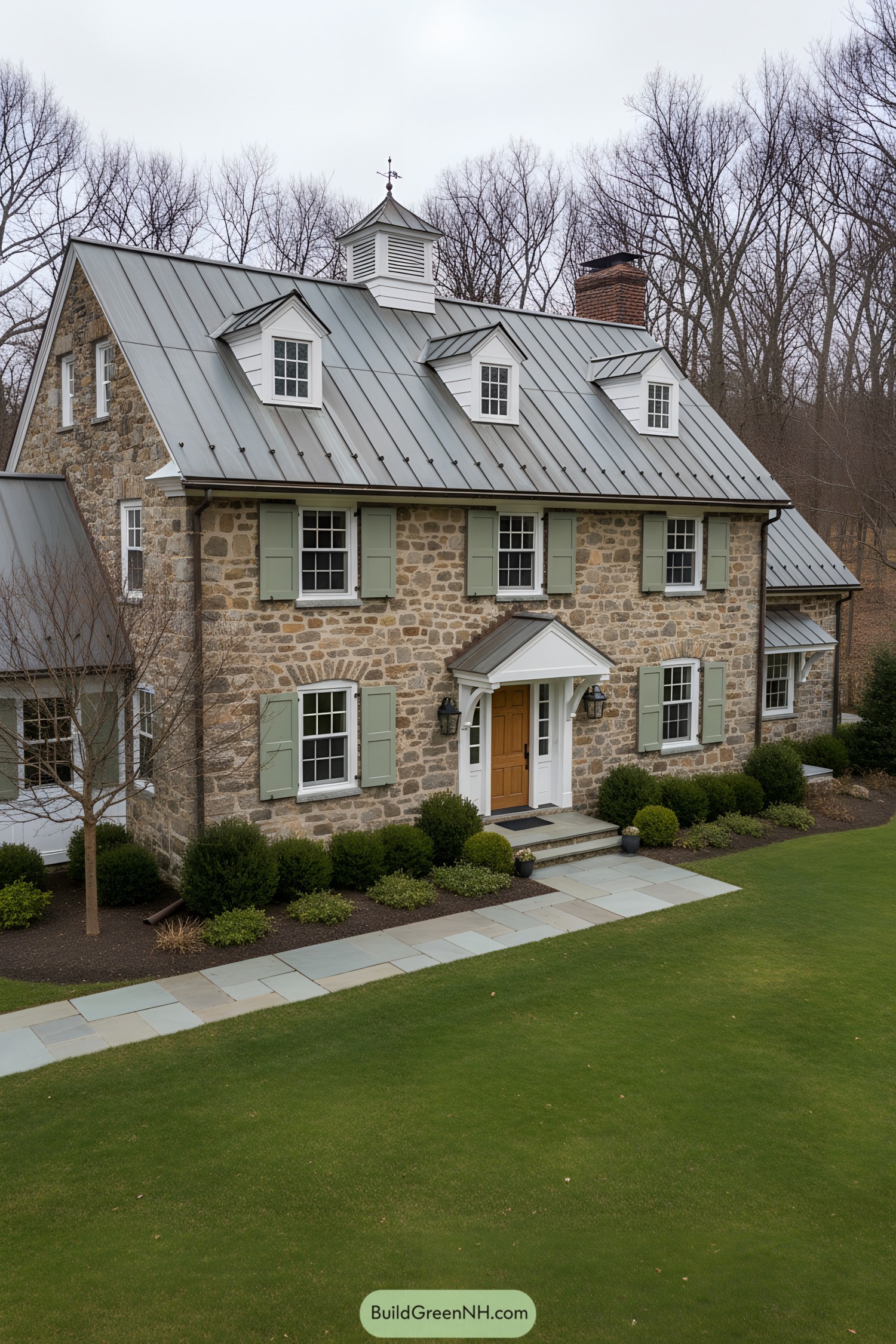 Two-story stone gambrel with metal roof, dormers, and sage shutters