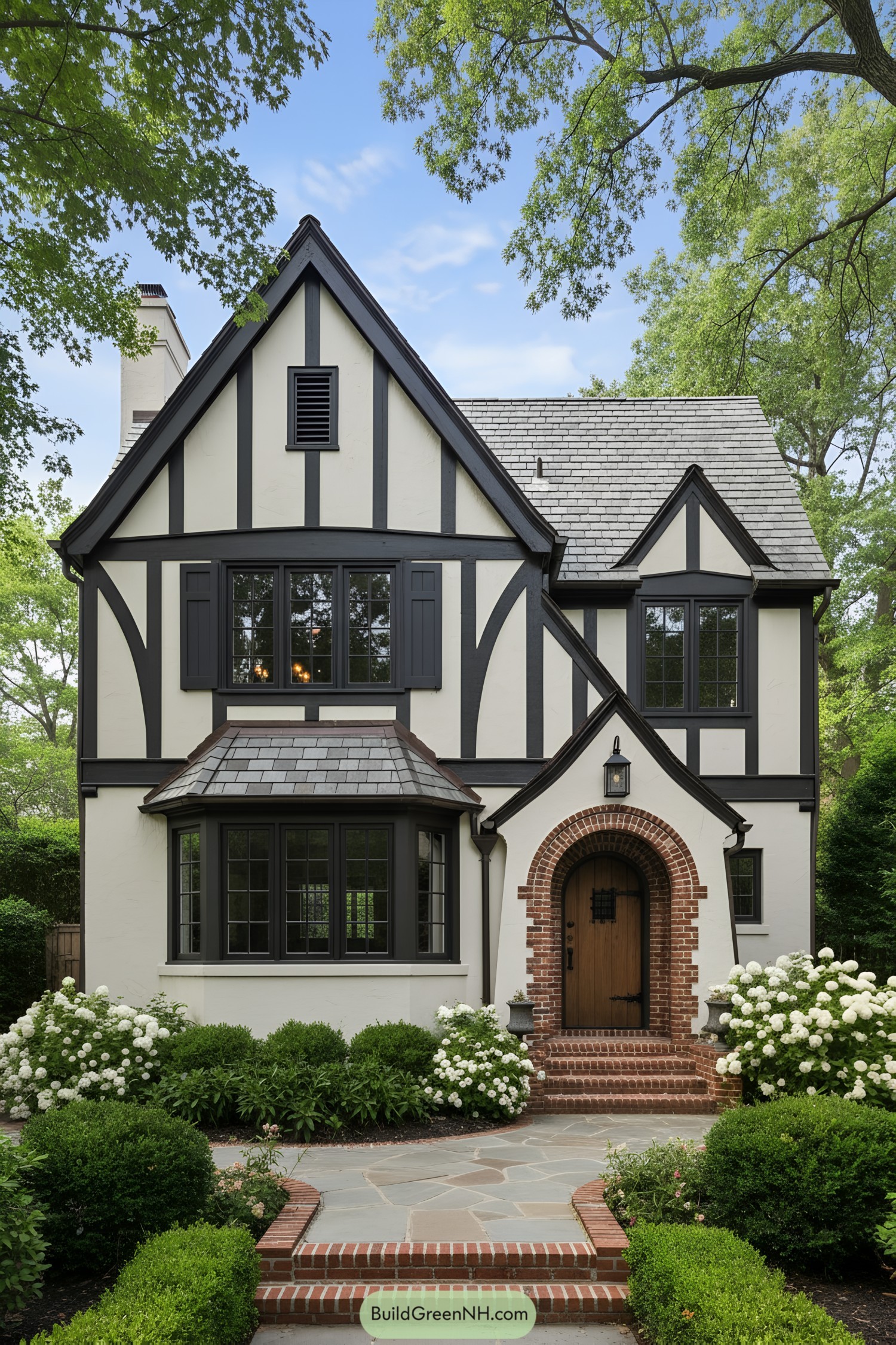 Black-and-cream Tudor with arched brick entry and slate roof