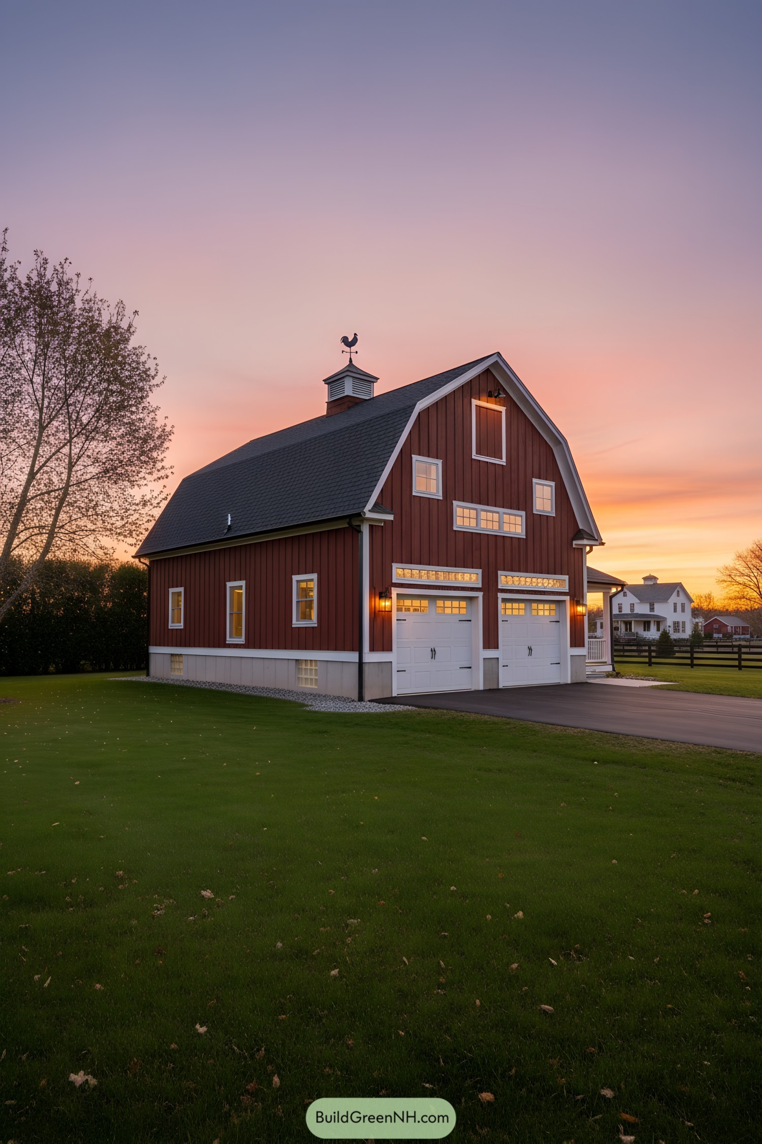Red gambrel barn-style house with double white garage doors at sunset
