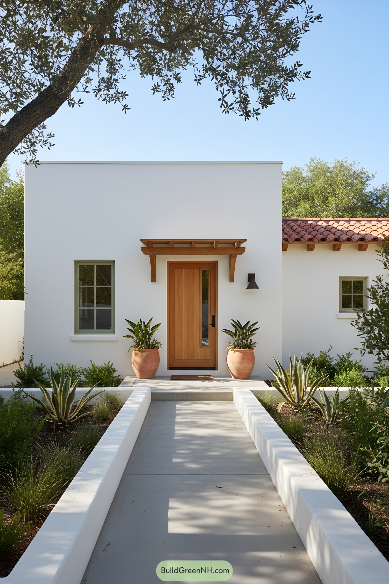 White stucco farmhouse with cedar door, clay tile wing, and drought-tolerant courtyard
