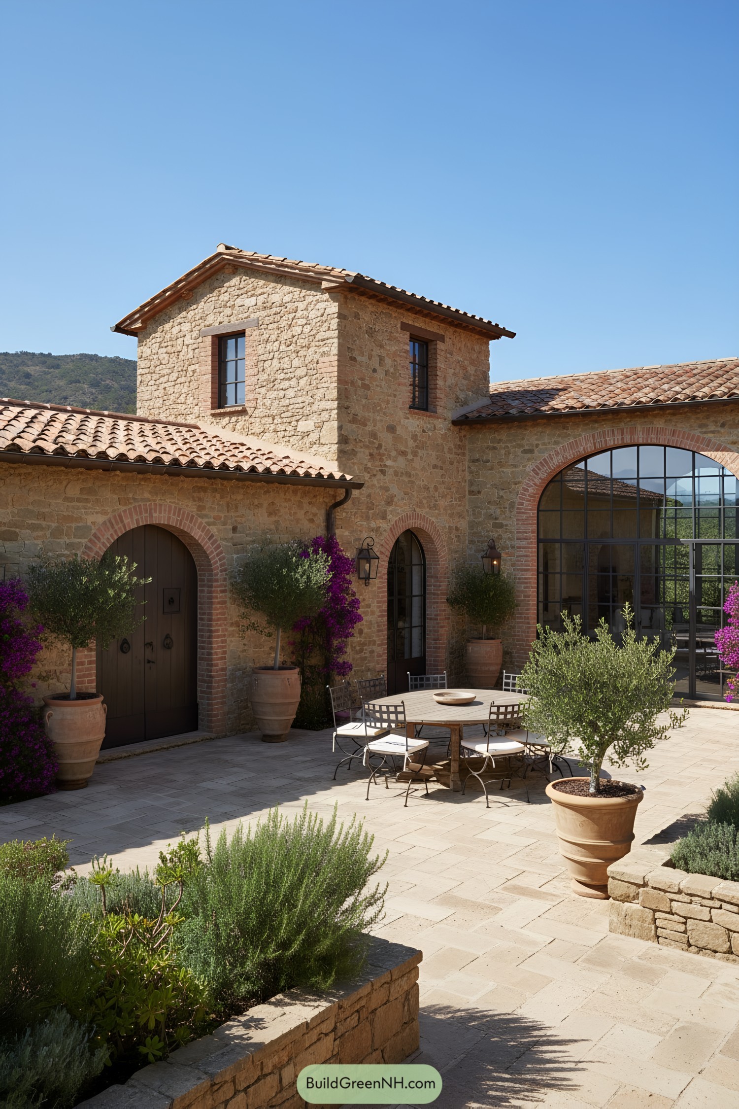 Stone farmhouse with tiled roofs and arched steel windows