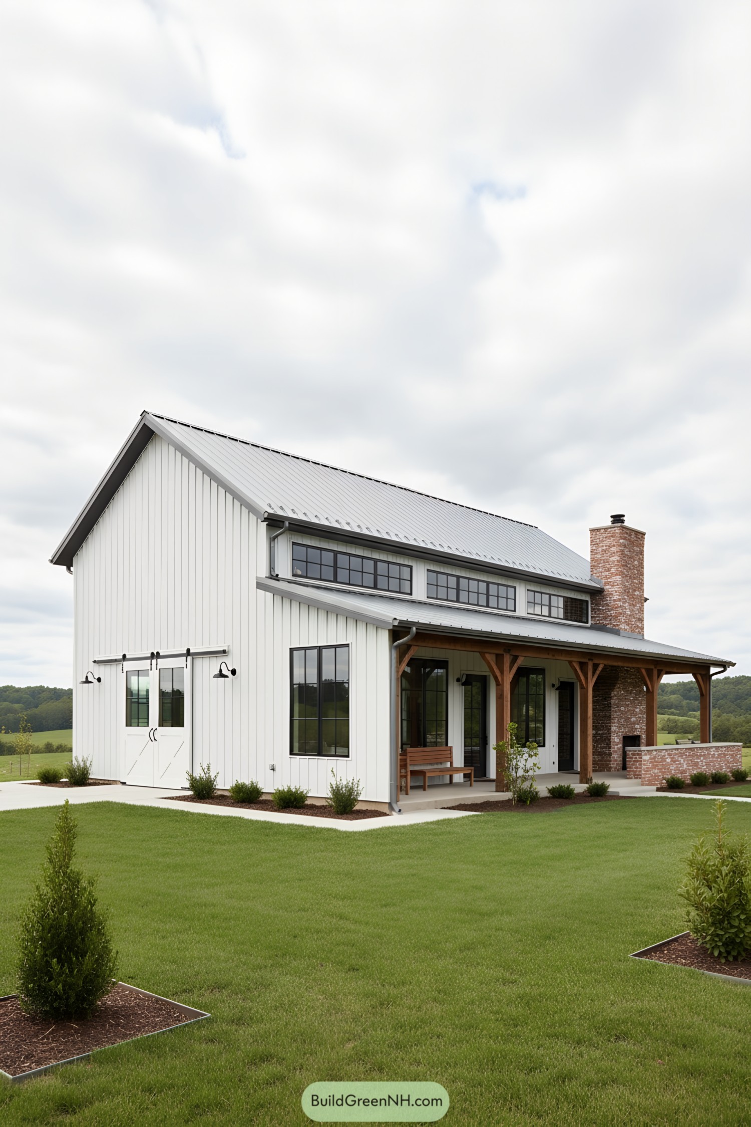 White metal barn home with clerestory windows, timber porch, and brick chimney
