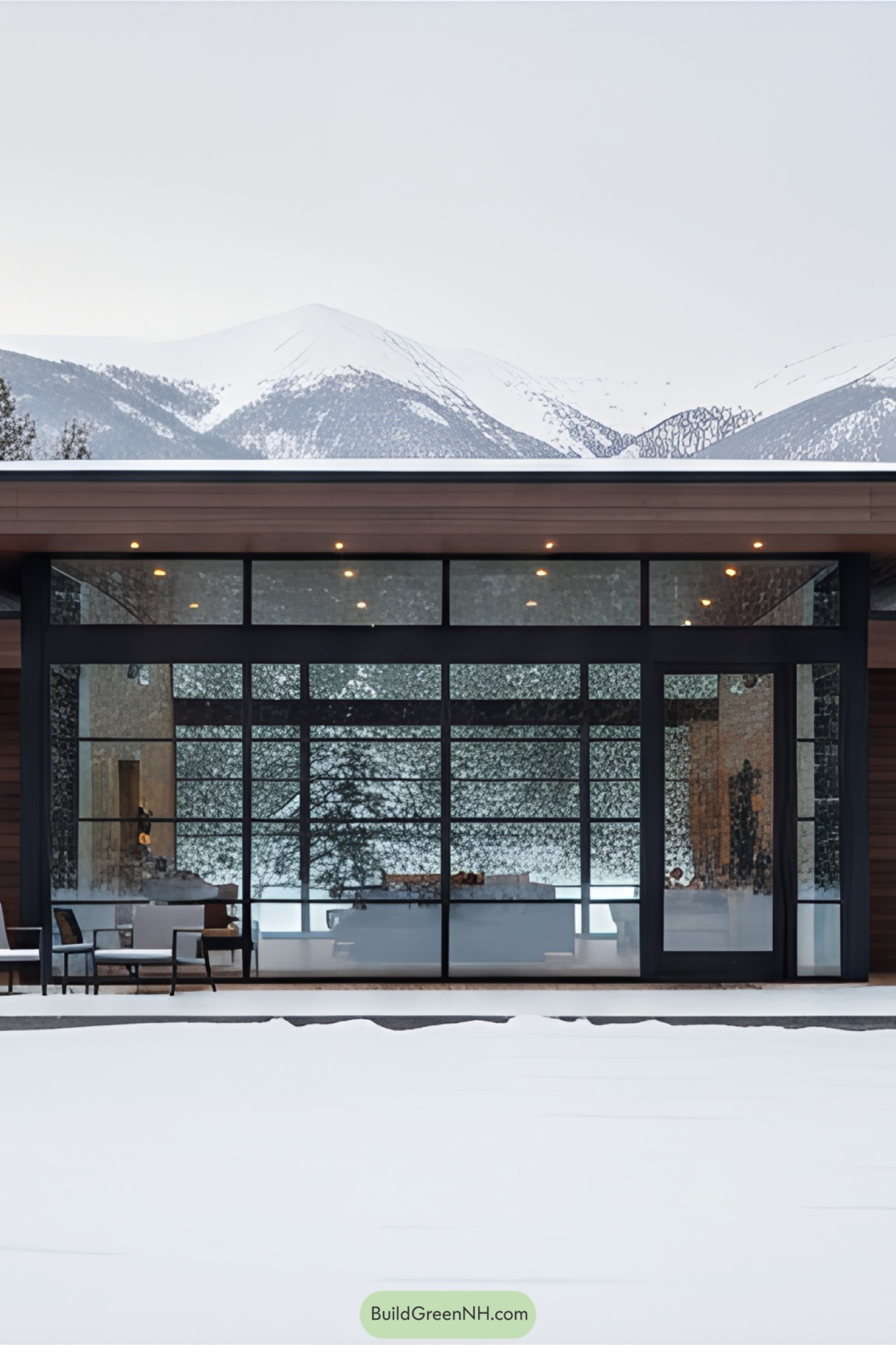 Modern house with large glass windows in a snowy mountain setting