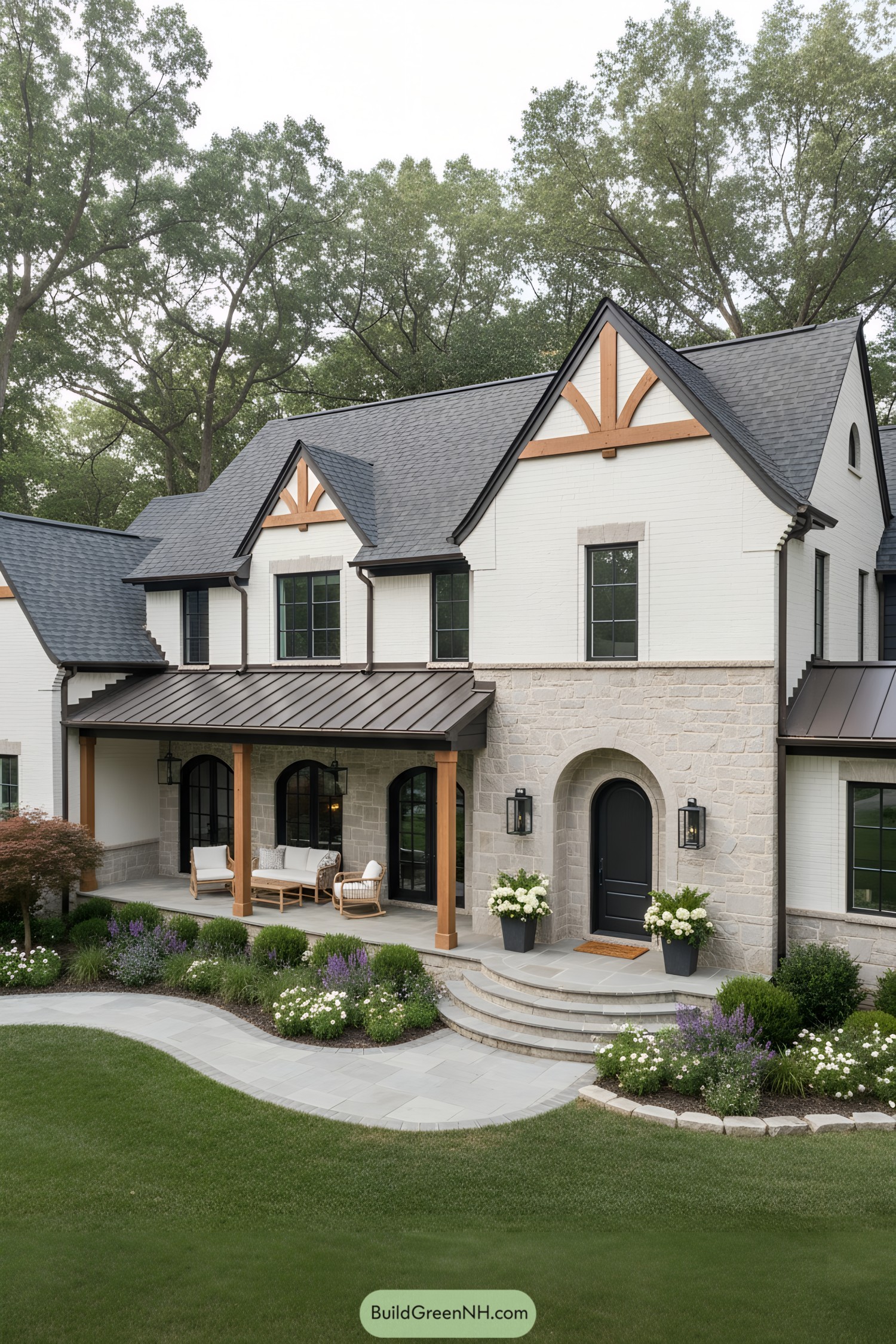Modern Tudor with white brick, stone base, black arched door, timber gables, and metal porch roof
