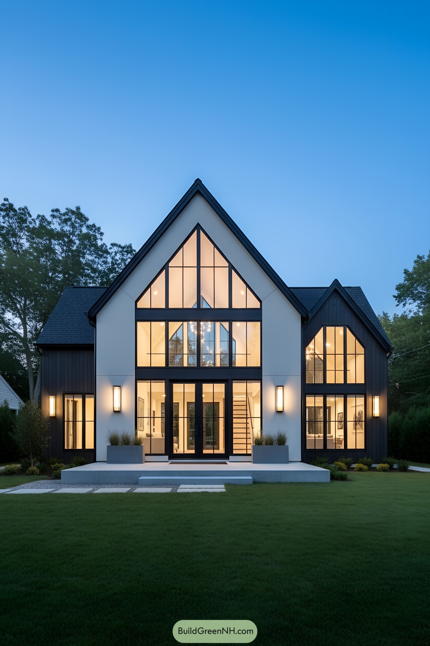 Steep-gabled modern house with full-height black-grid windows and a white-and-charcoal facade at dusk