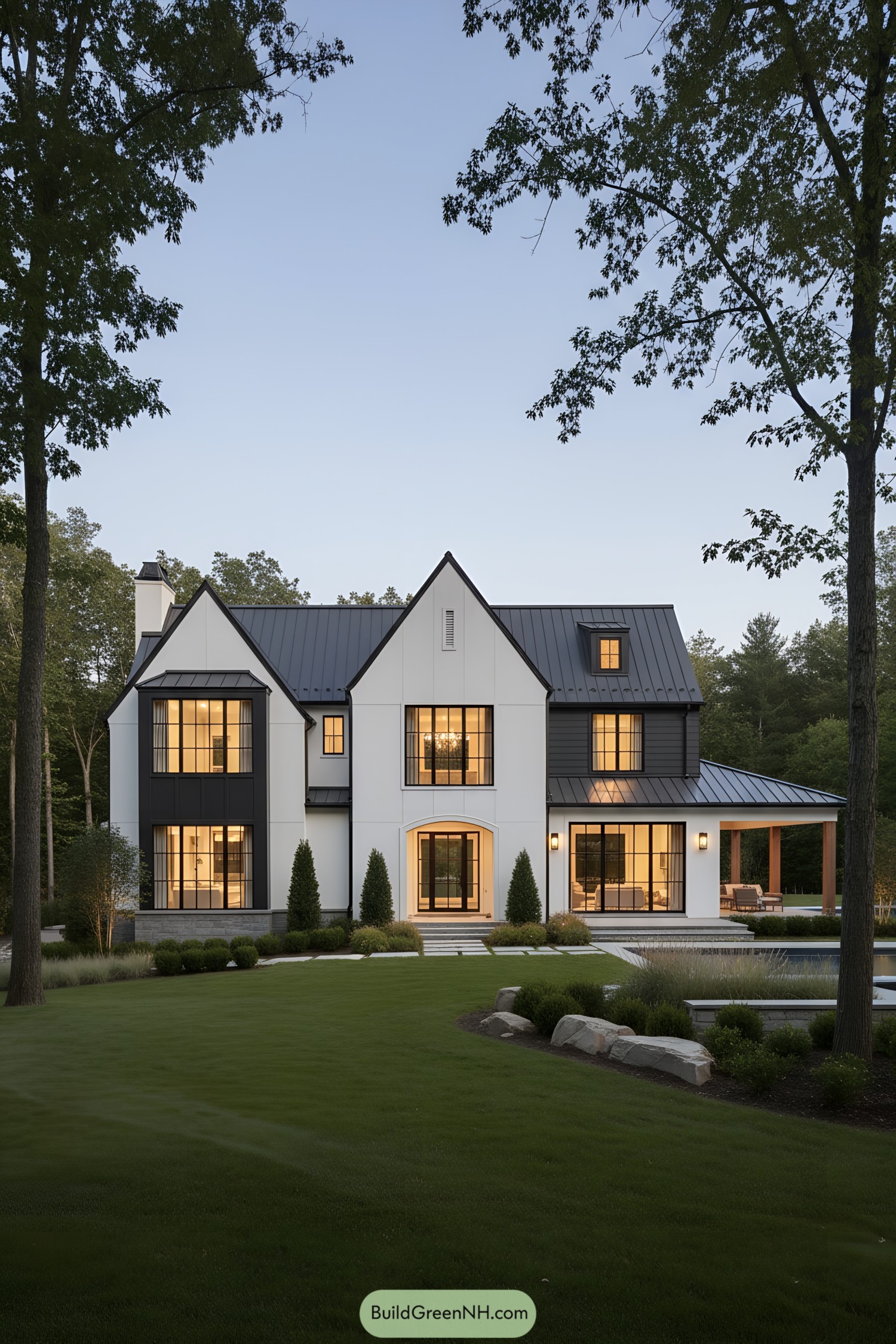 Modern Tudor mansion with black metal roof and white stucco