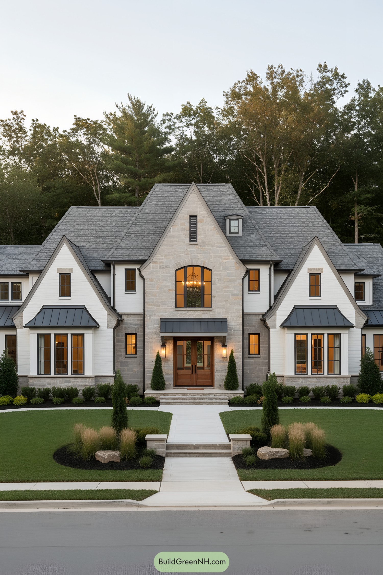 Modern Tudor mansion with gray gables, stone facade, and wood double doors