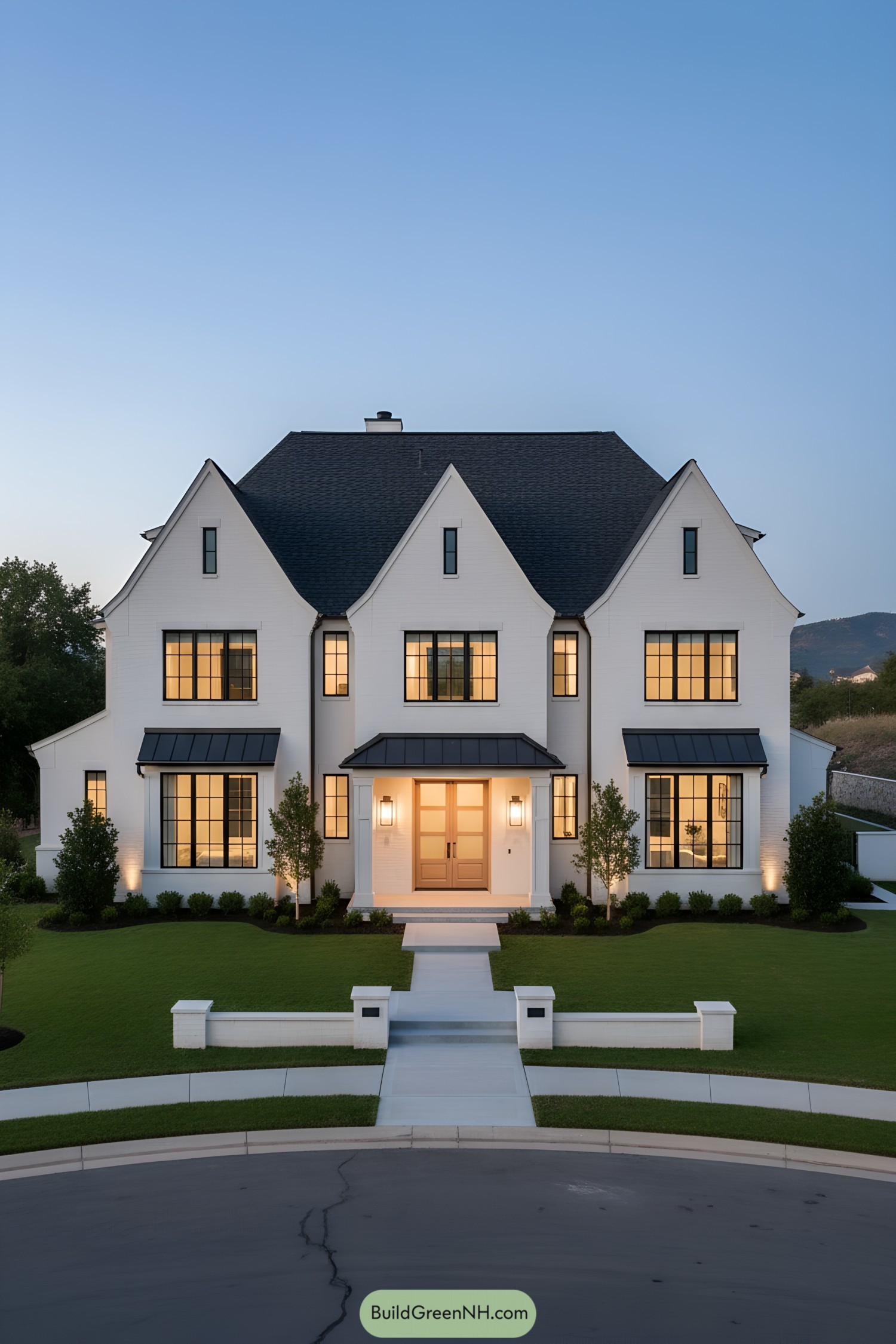 White modern Tudor mansion at dusk