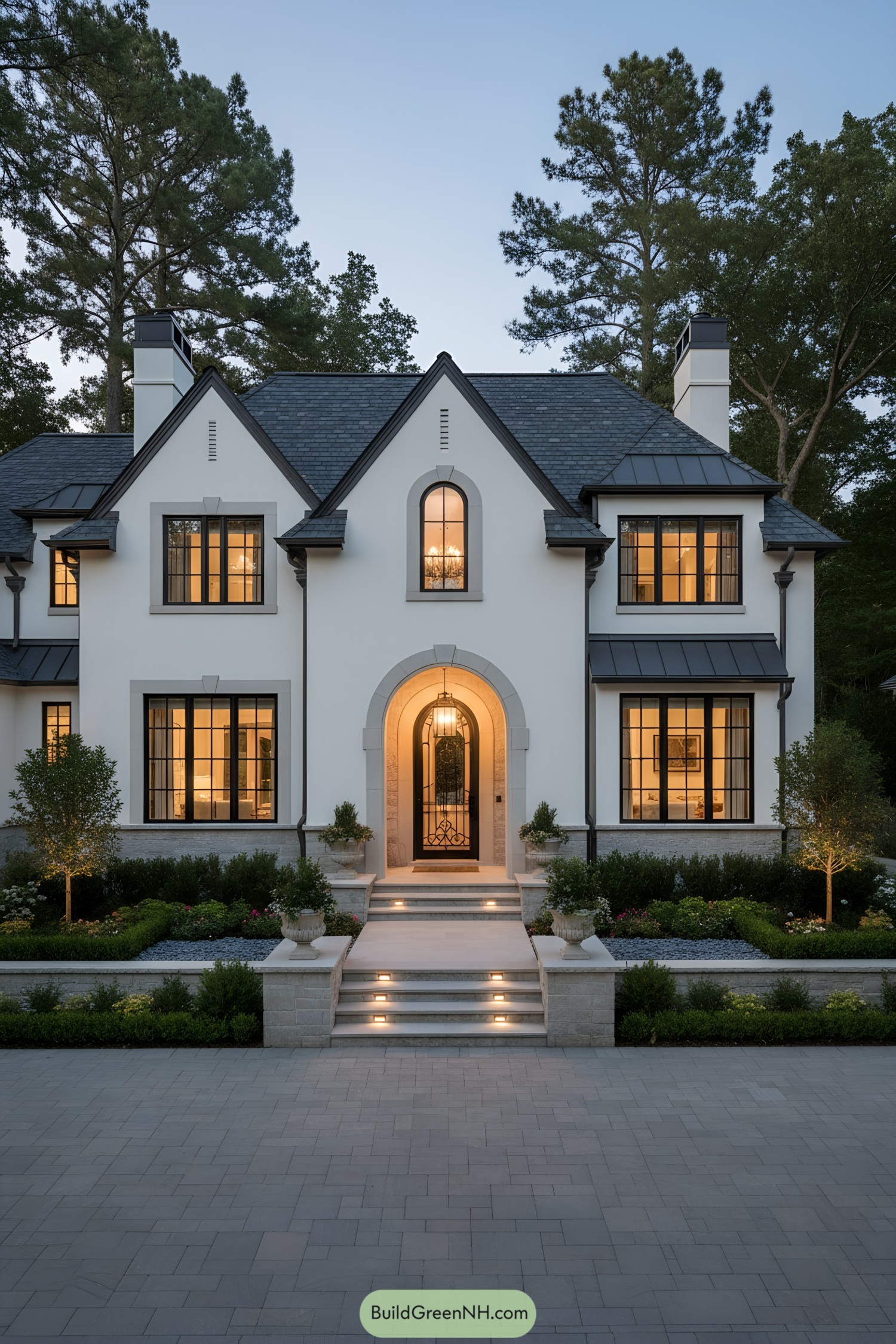 Modern Tudor home with white stucco, dark gables, and arched entry