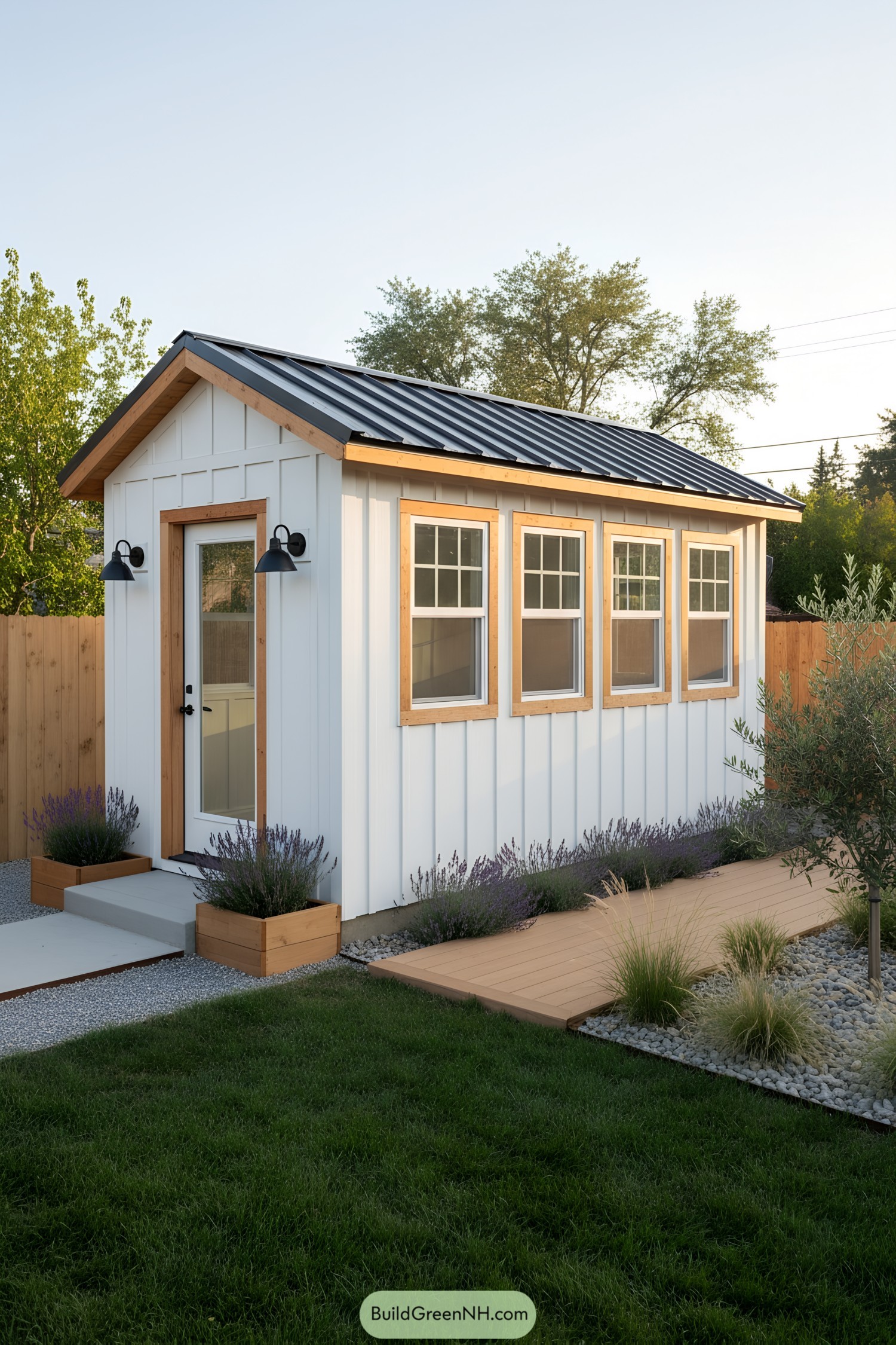 Small white shed office with wood trim and black metal roof