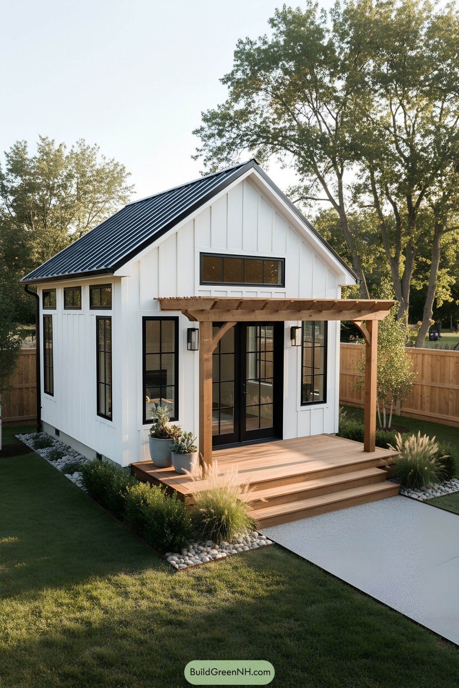 White board-and-batten shed with black windows and a small wood pergola porch