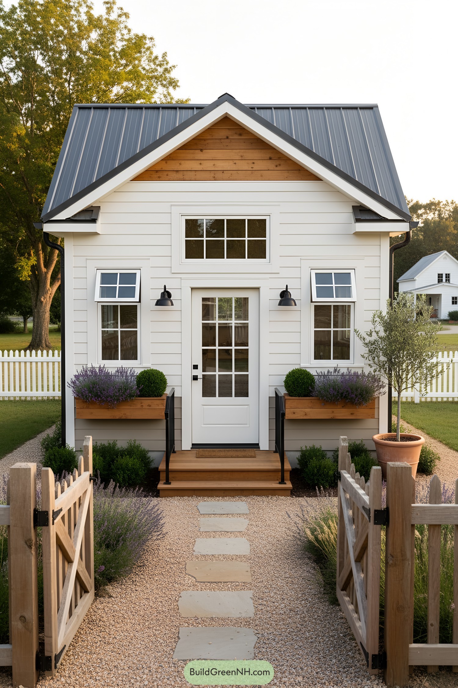 White clapboard she shed with gabled roof and planter boxes by entry