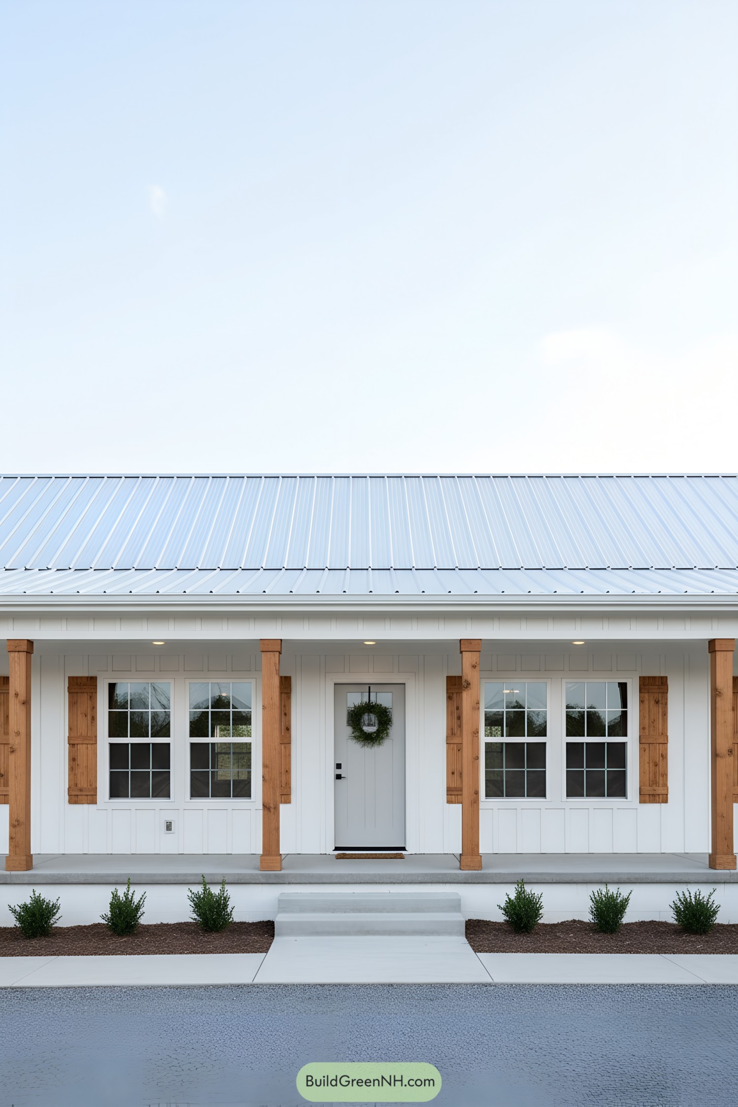 White farmhouse-style shed with metal roof, cedar posts, and shutter accents