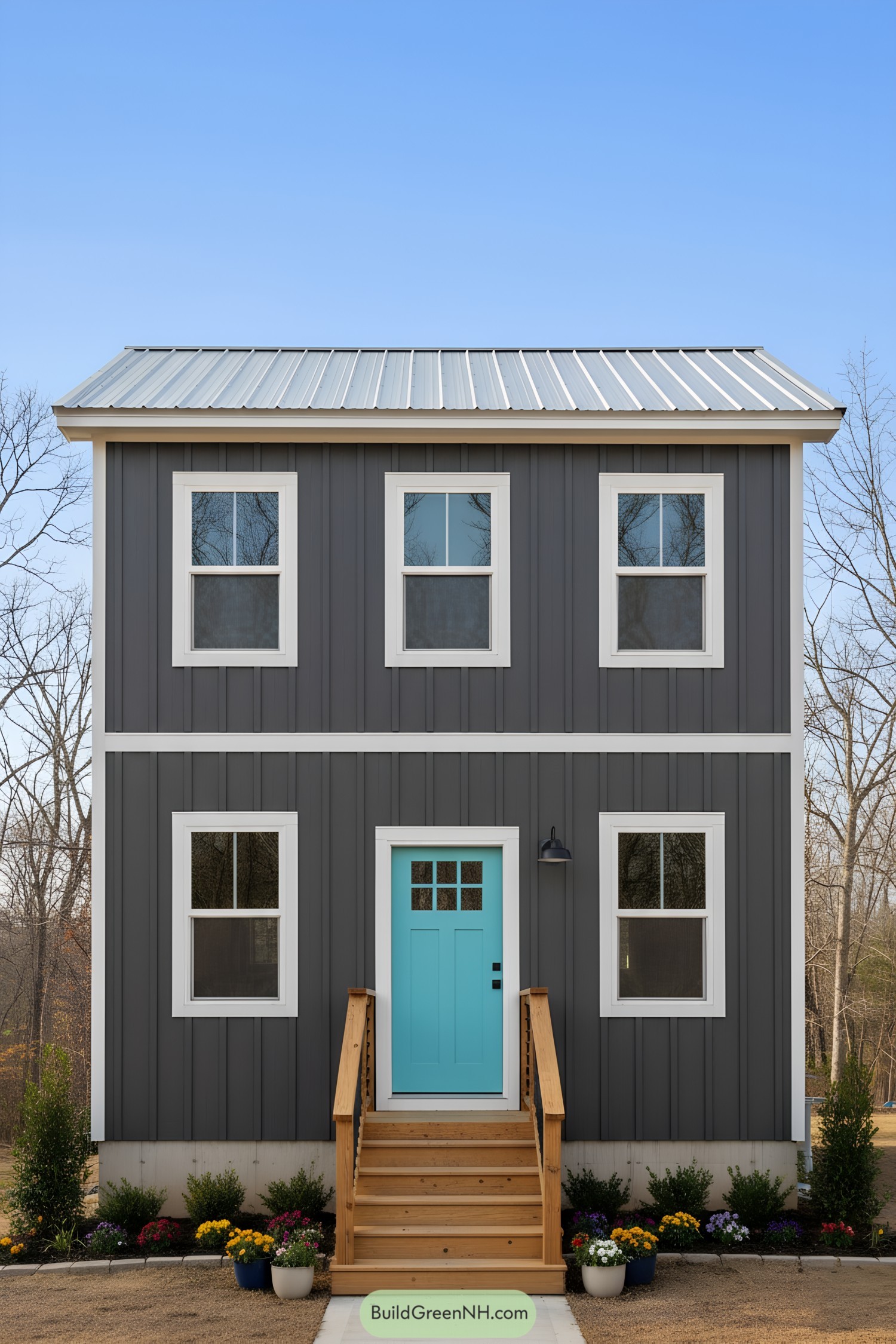 Dark vertical-siding shed home with teal door, metal roof, and centered steps