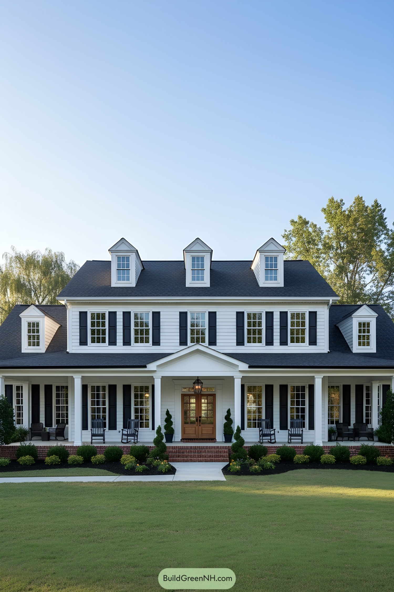 White clapboard house with black shutters, deep porch, and three dormers