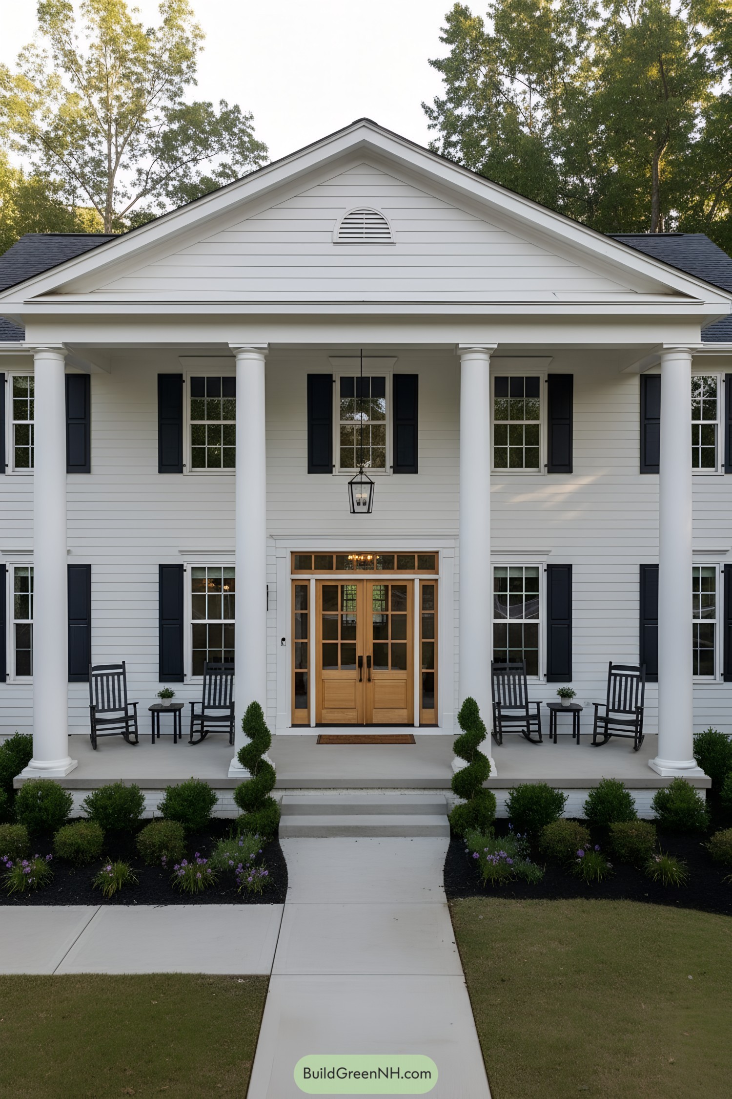 White clapboard colonial with tall columns, black shutters, and double wooden entry doors