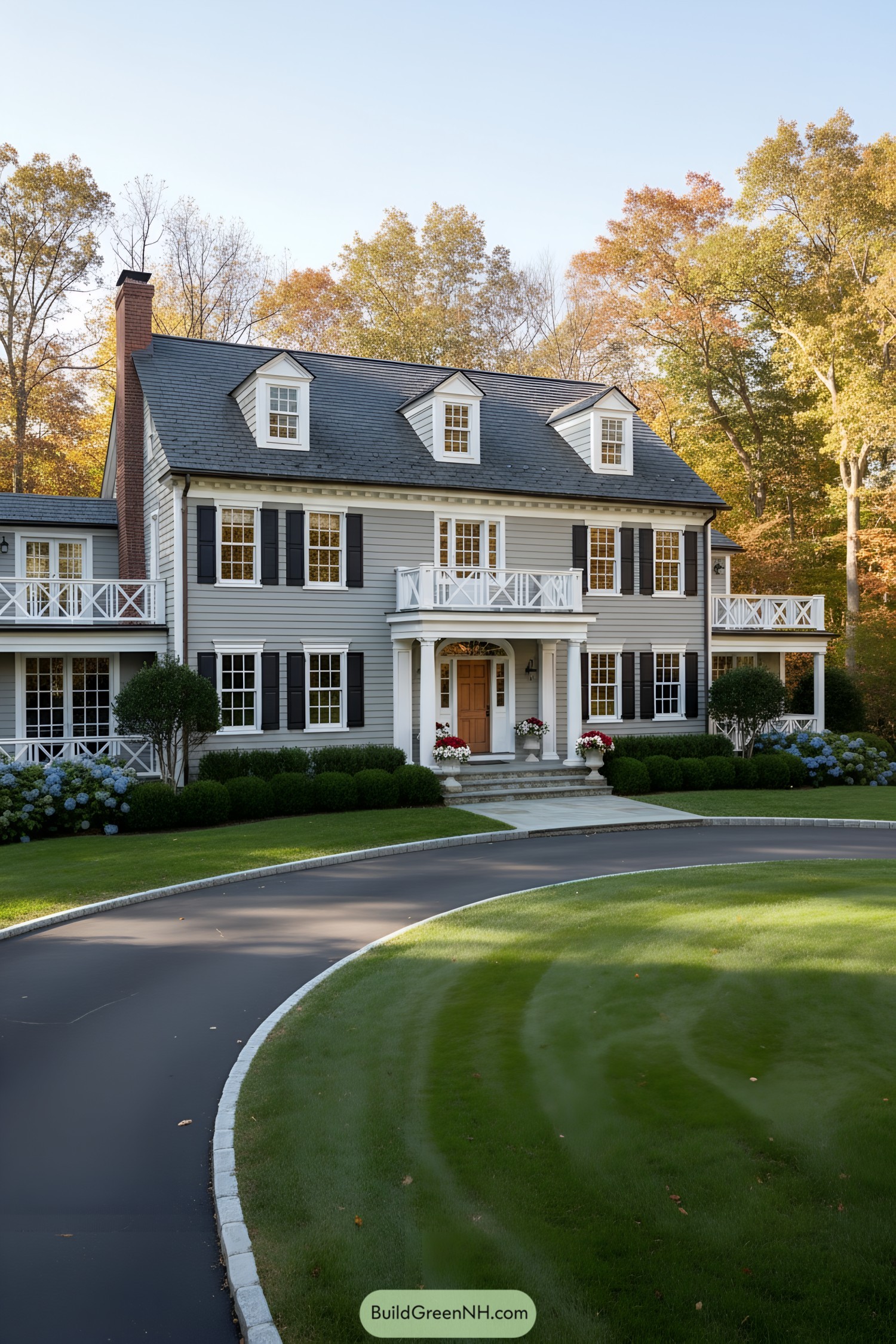Gray clapboard colonial with black shutters and dormers