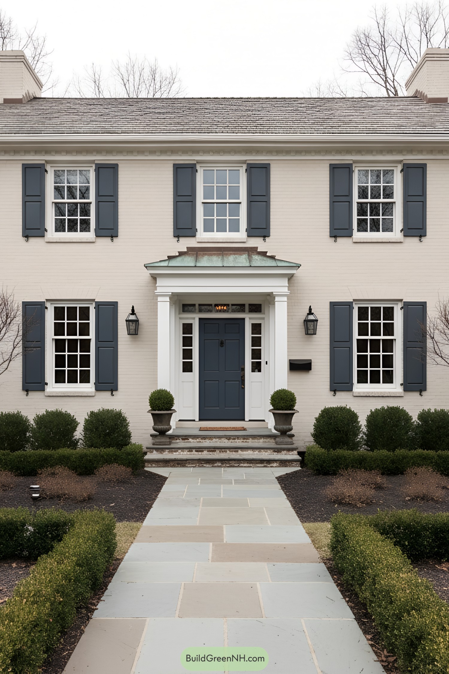 Two-story colonial with blue shutters, centered door, and copper-topped portico