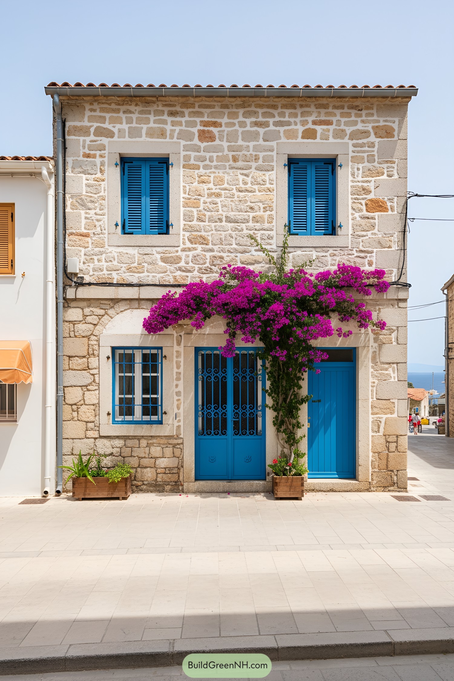 Mediterranean stone house with blue doors and bougainvillea