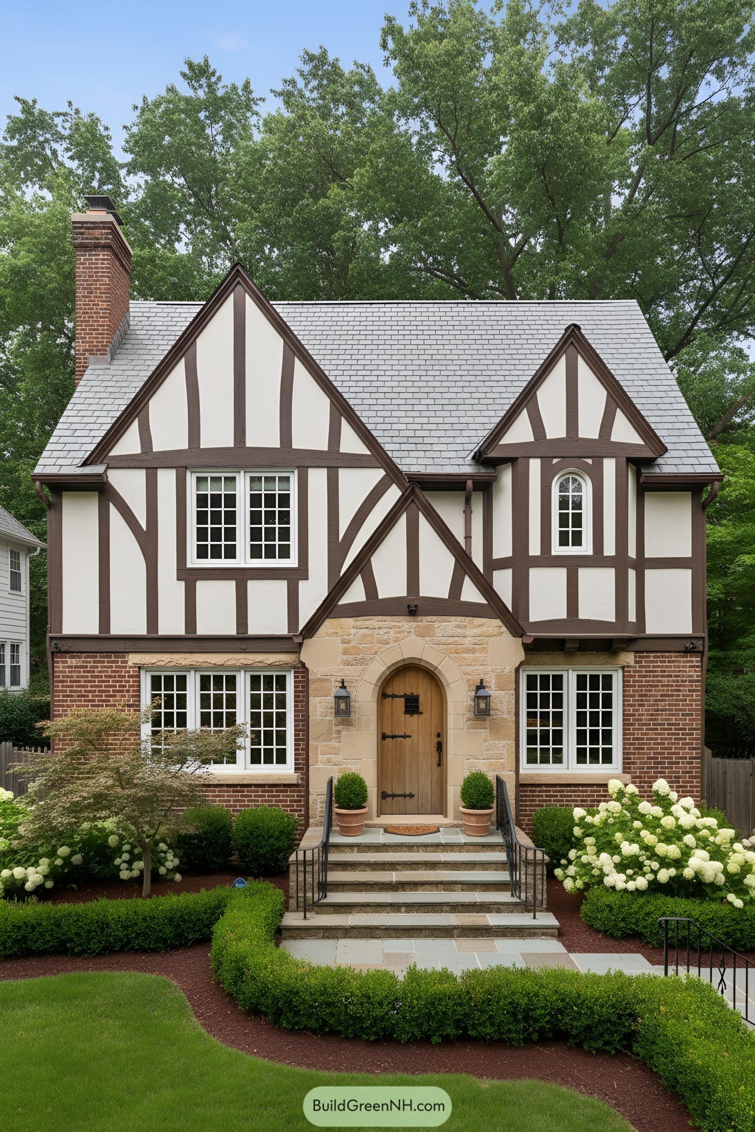 Tudor facade with slate roof, stone arched entry, and half-timber detailing
