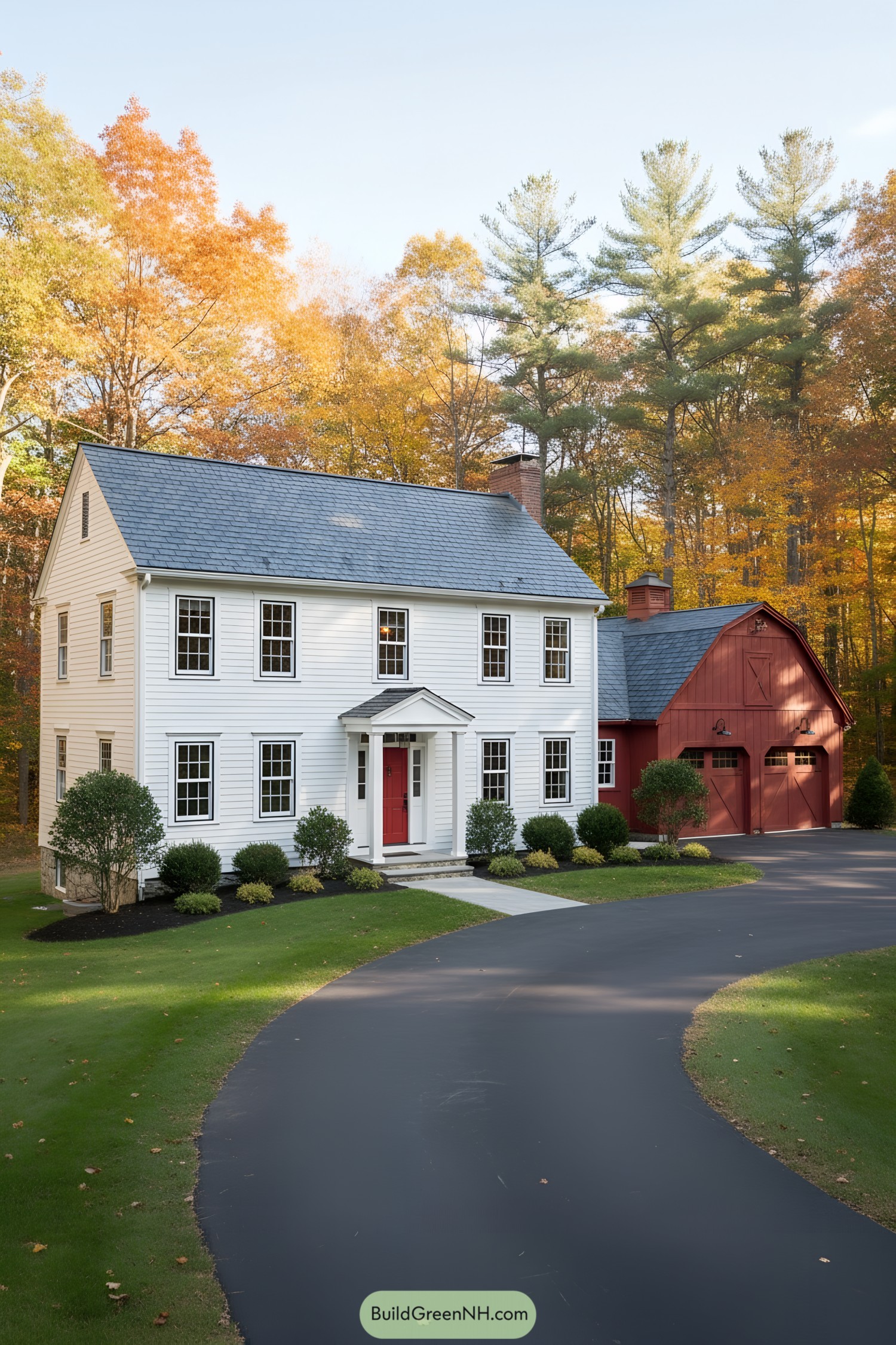 White colonial home with red barn-style garage and red front door