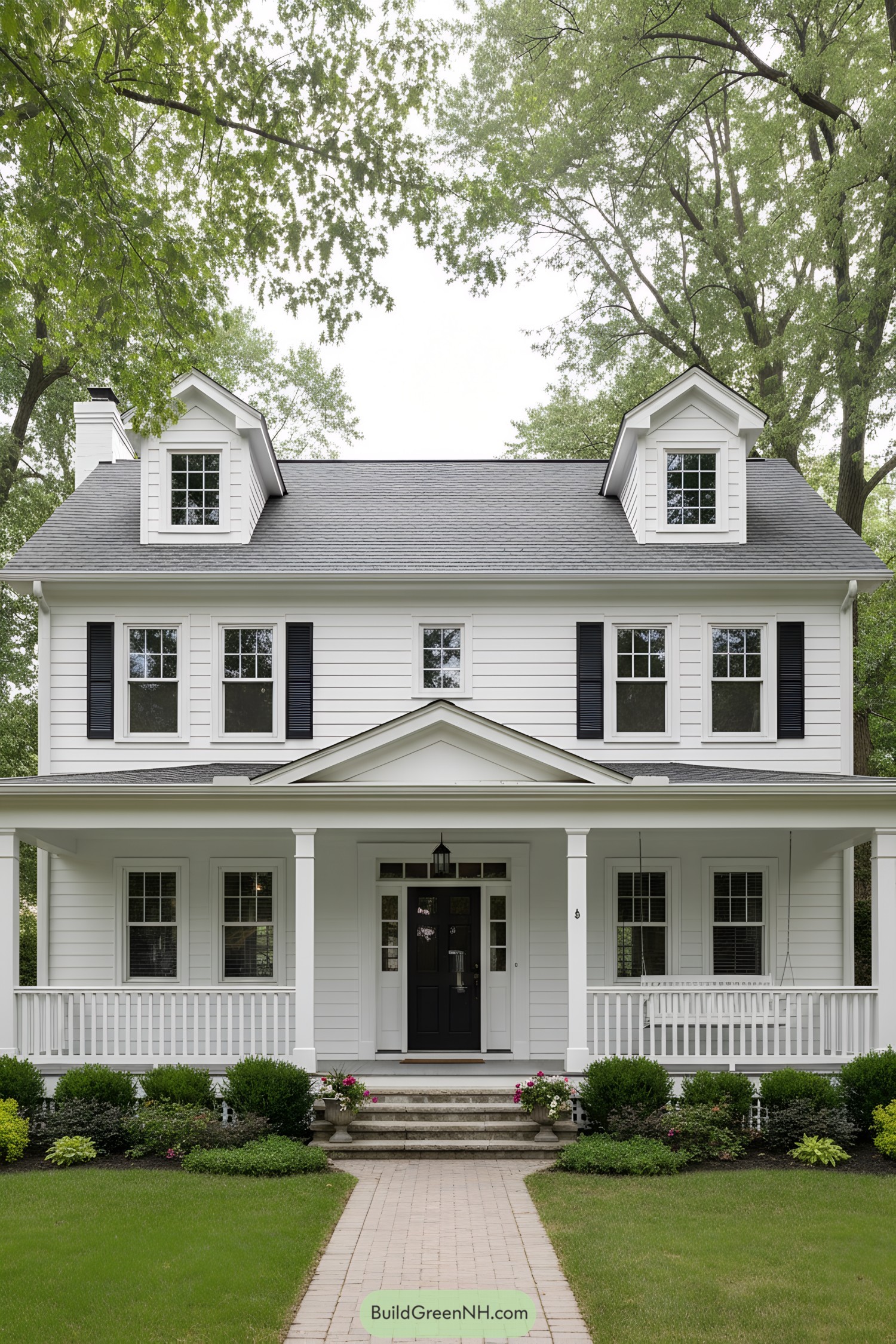White colonial with dormers, wraparound porch, black door