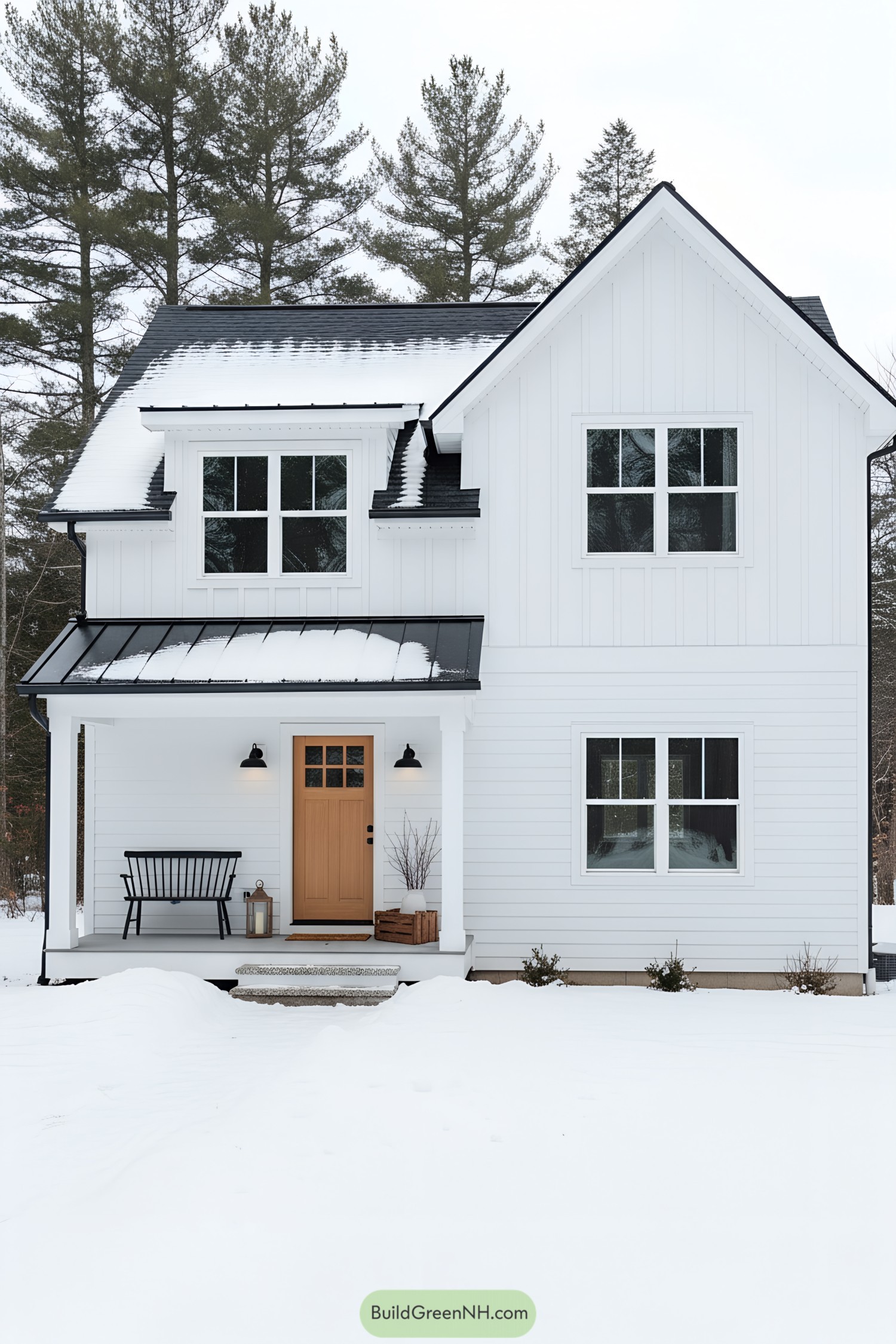 White gabled cottage with black roof in snow