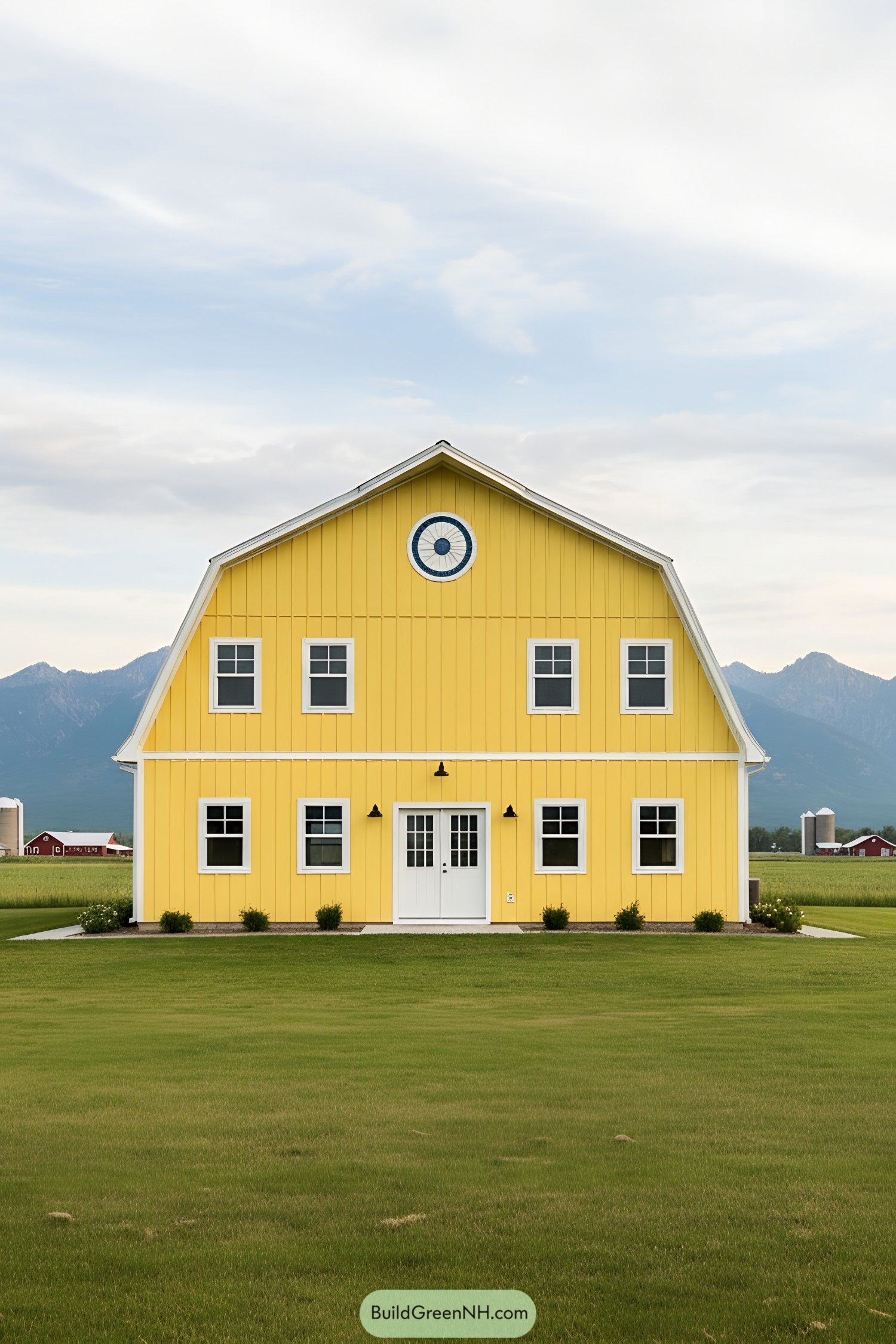 Yellow barndominium with a cloudy sky in the background