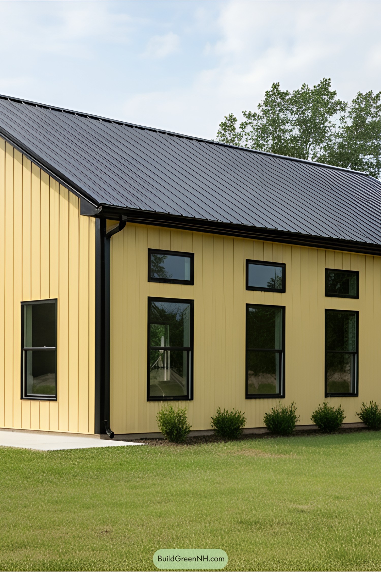 Yellow barndominium with black roof and windows