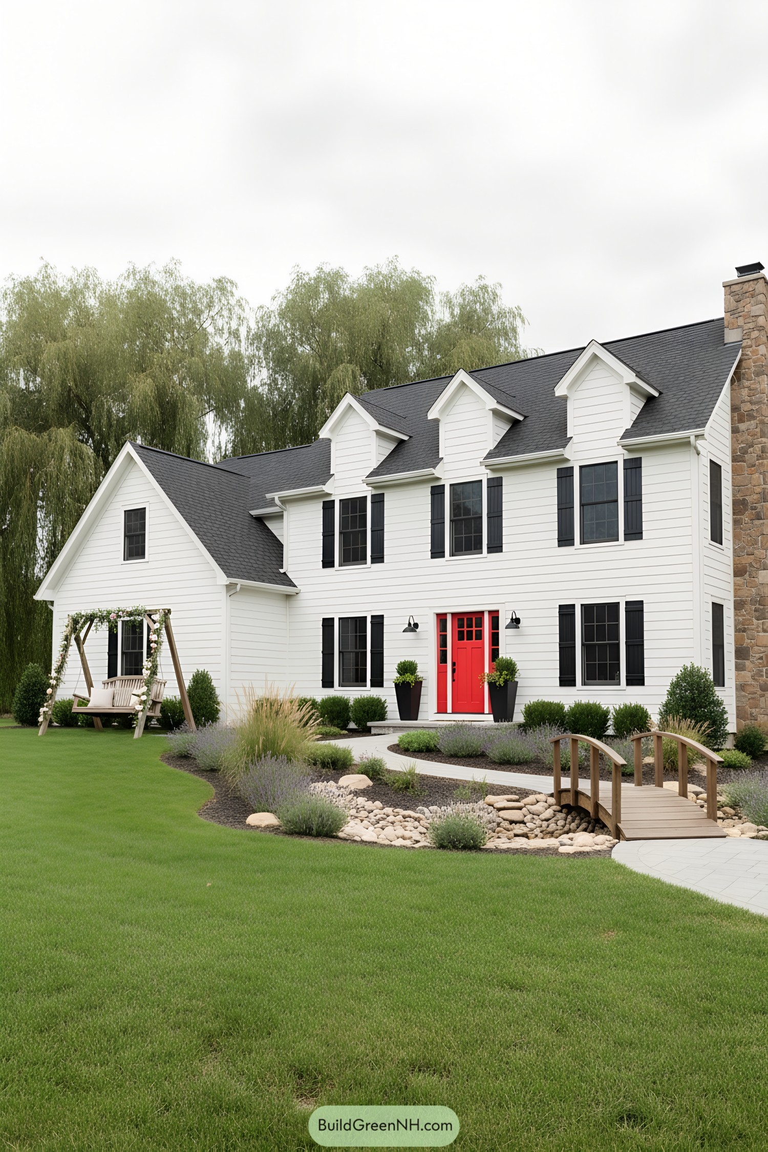White colonial with black shutters, red door, stone chimney, and a small wooden bridge