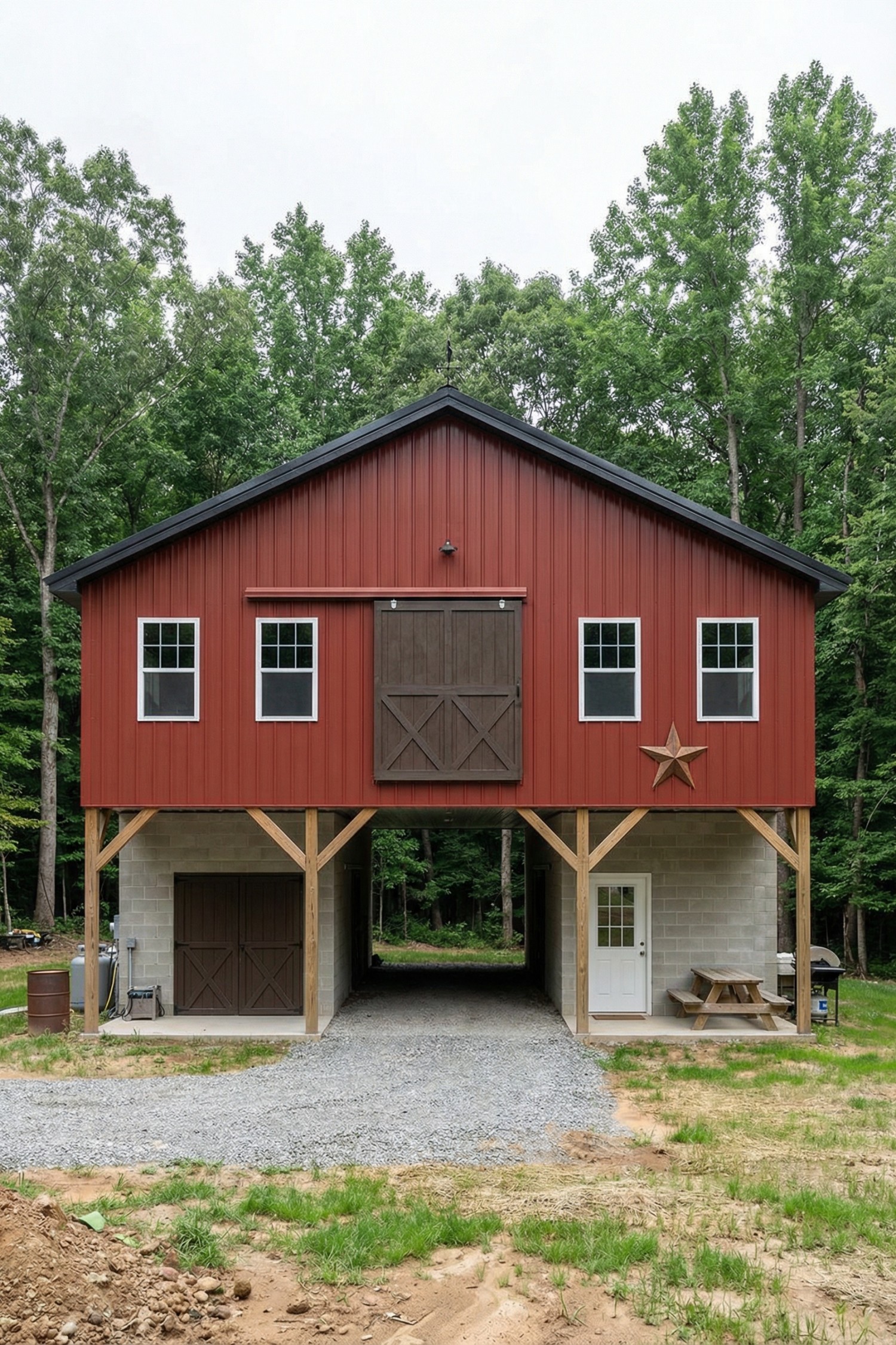 Red metal barn on stilts with central drive-through and loft door