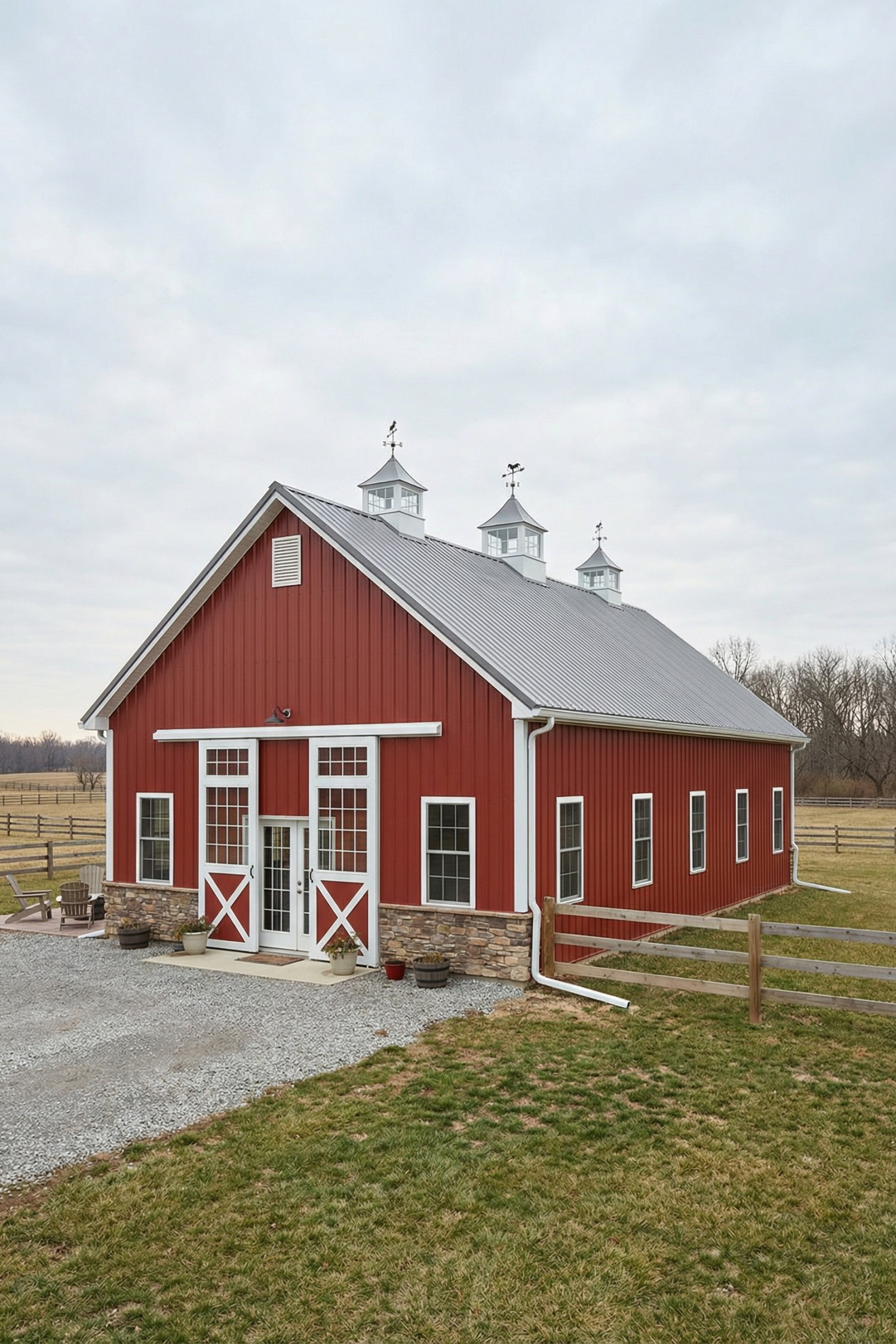 Red barn with stone base and three cupolas