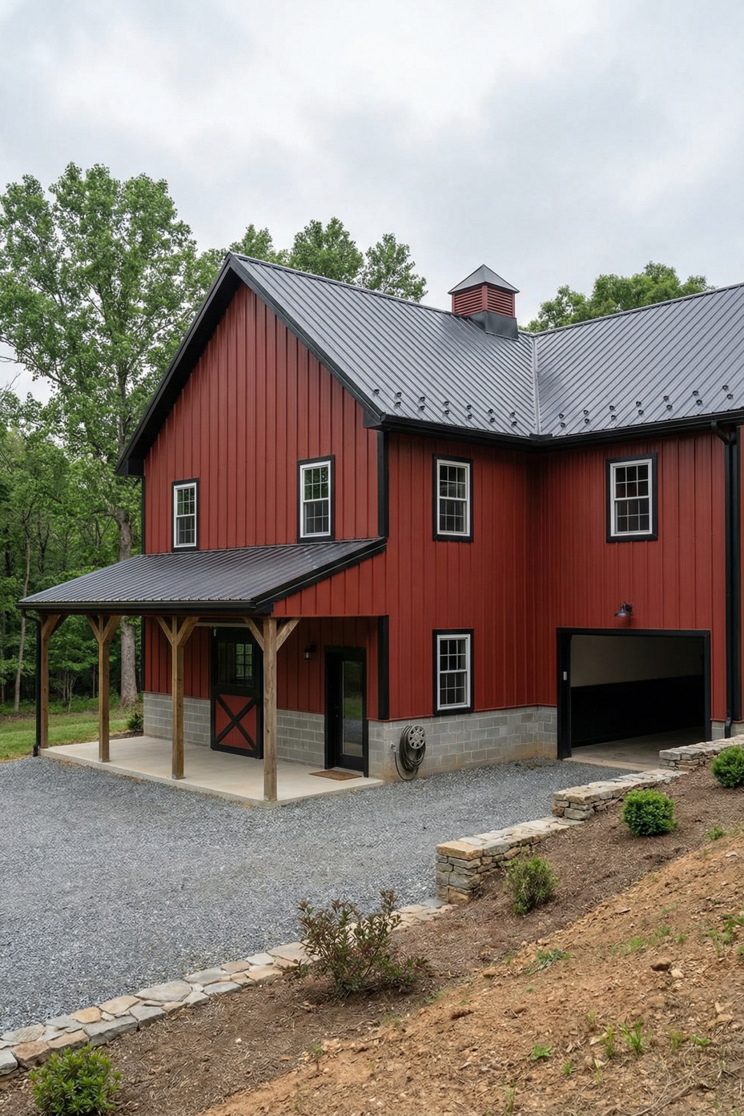 Red metal-roof barnhouse with porch and garage