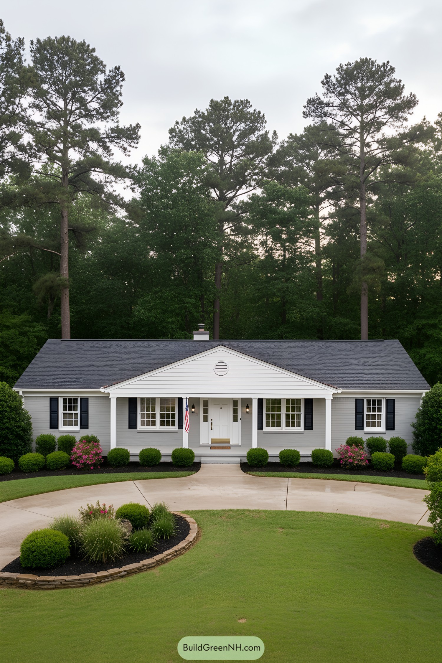 Single-story gray ranch with white portico and black shutters, framed by manicured shrubs and a circular driveway