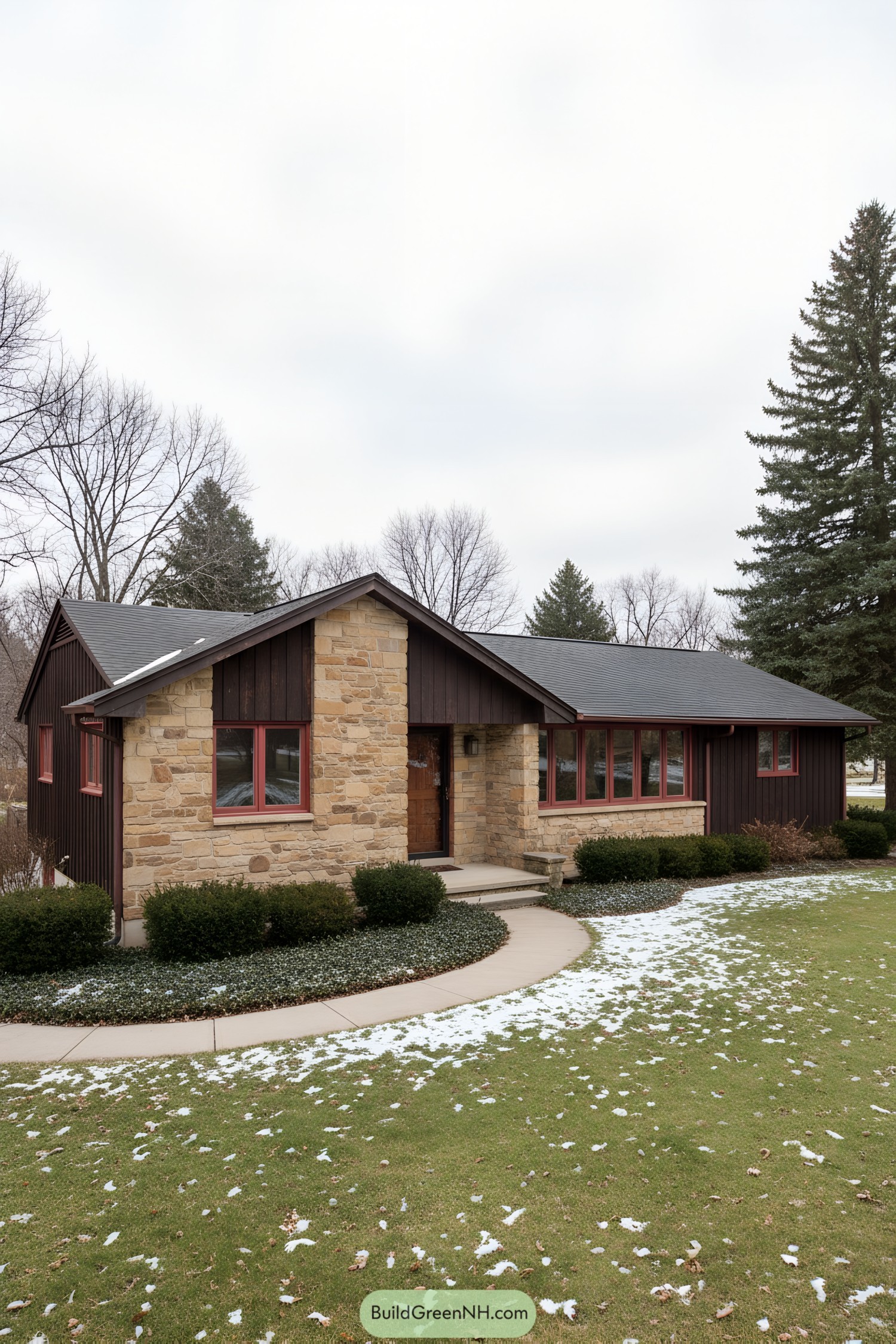 Low-slung ranch with stone and dark siding, red-trimmed windows, and a central gable entry