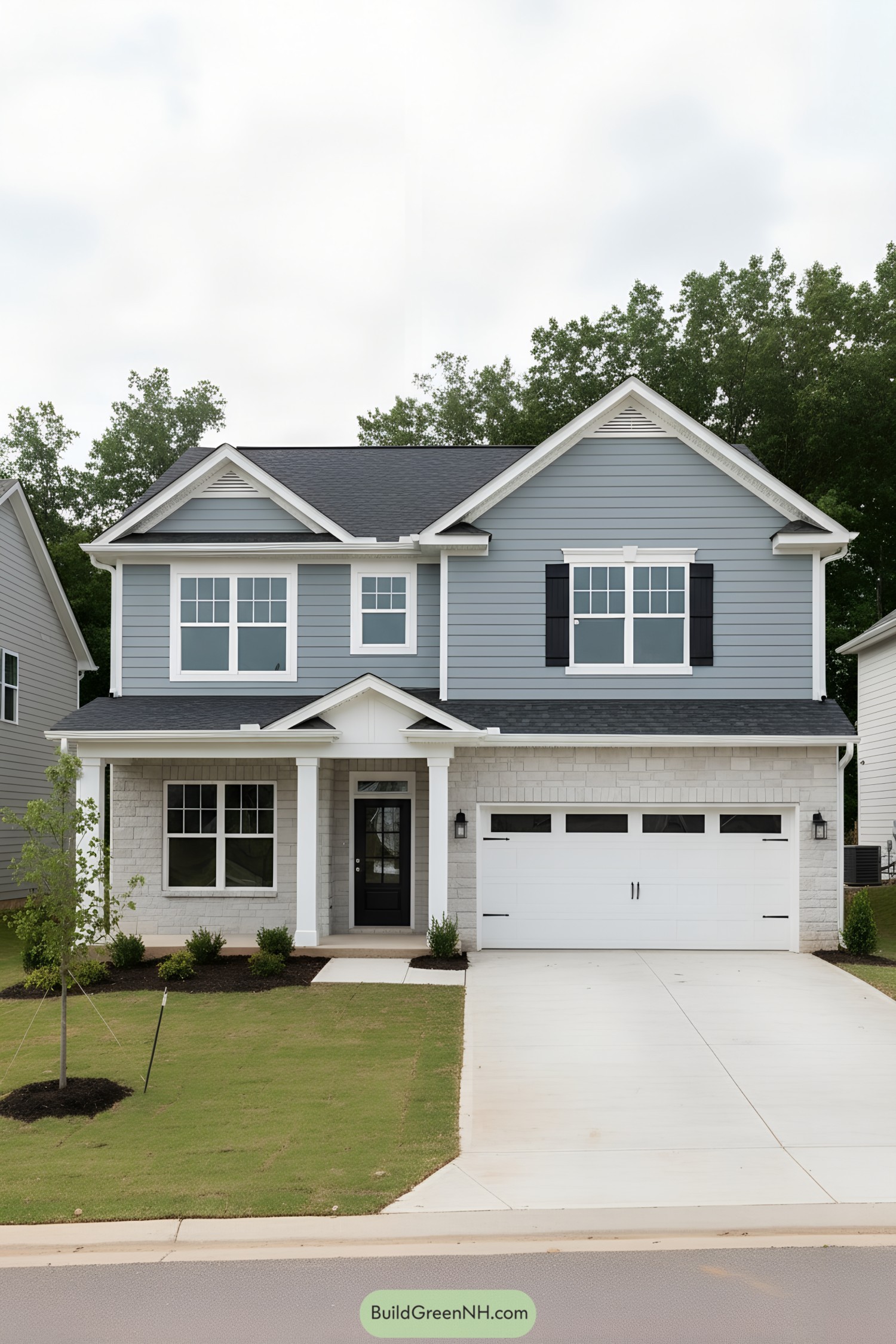 Two-story blue house with white trim, porch, and double garage