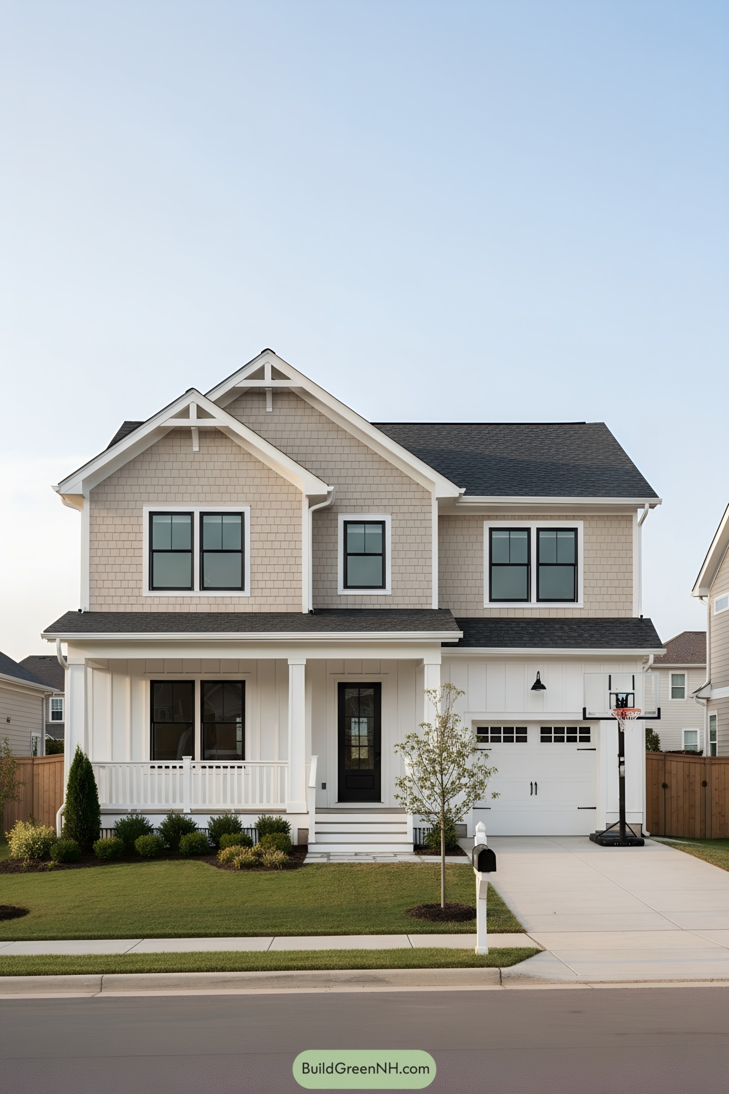 Two-story white house with front porch, shingle gables, and black-trim windows