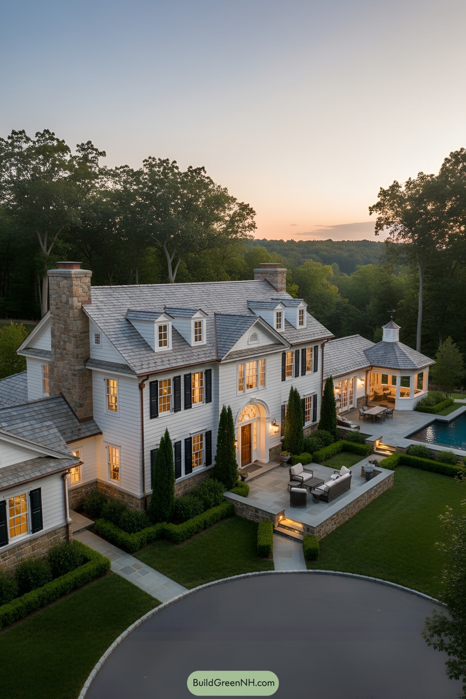 Elegant white manor with black shutters and slate roof at dusk